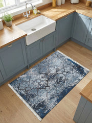 Tapis rectangulaire aux motifs abstraits et géométriques bleus, gris et blancs sur fond marine, posé dans une cuisine lumineuse
