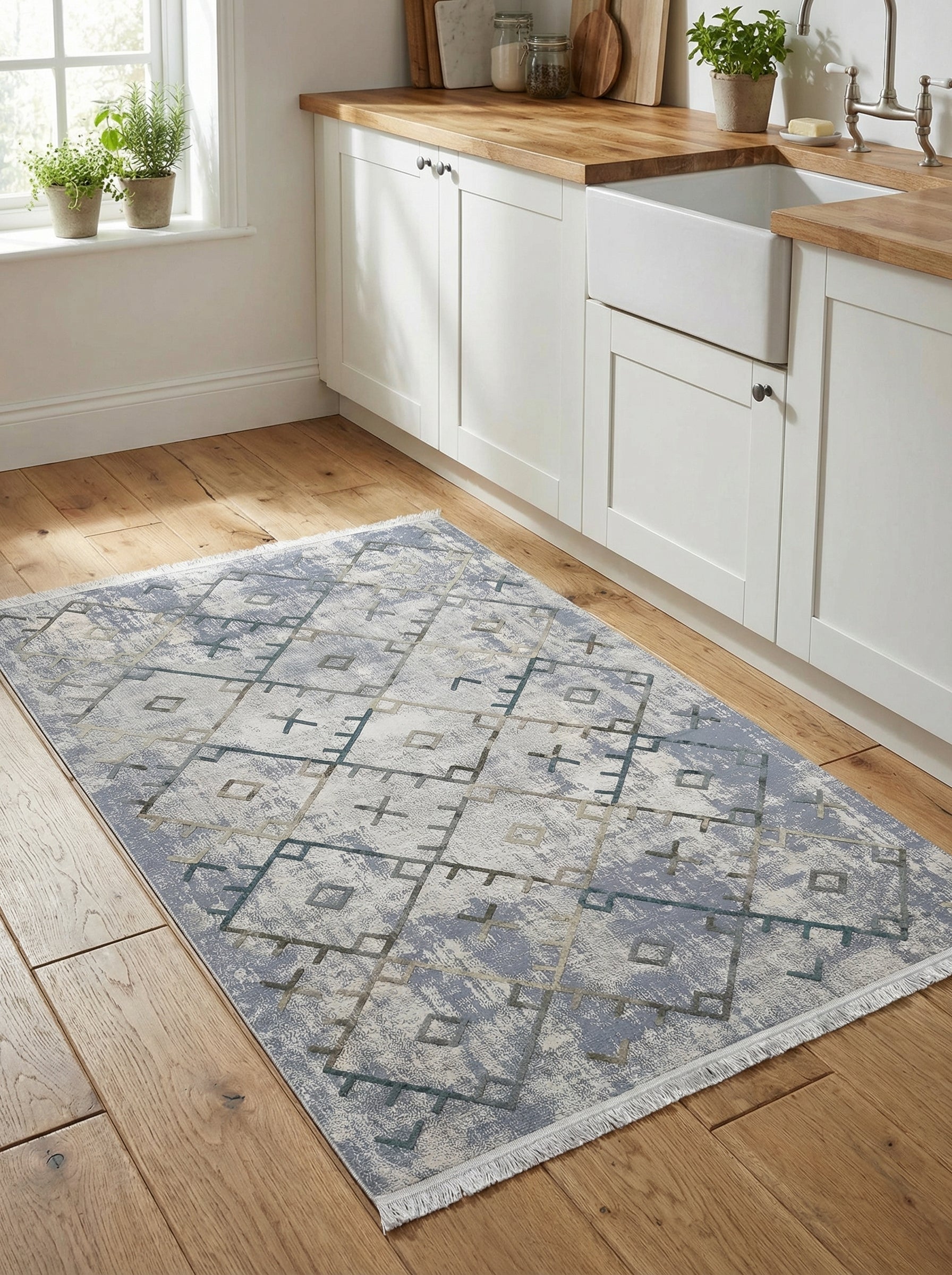 Tapis rectangulaire aux teintes de bleu clair, crème et gris avec motifs géométriques abstraits délavés sur un plancher en bois dans une cuisine