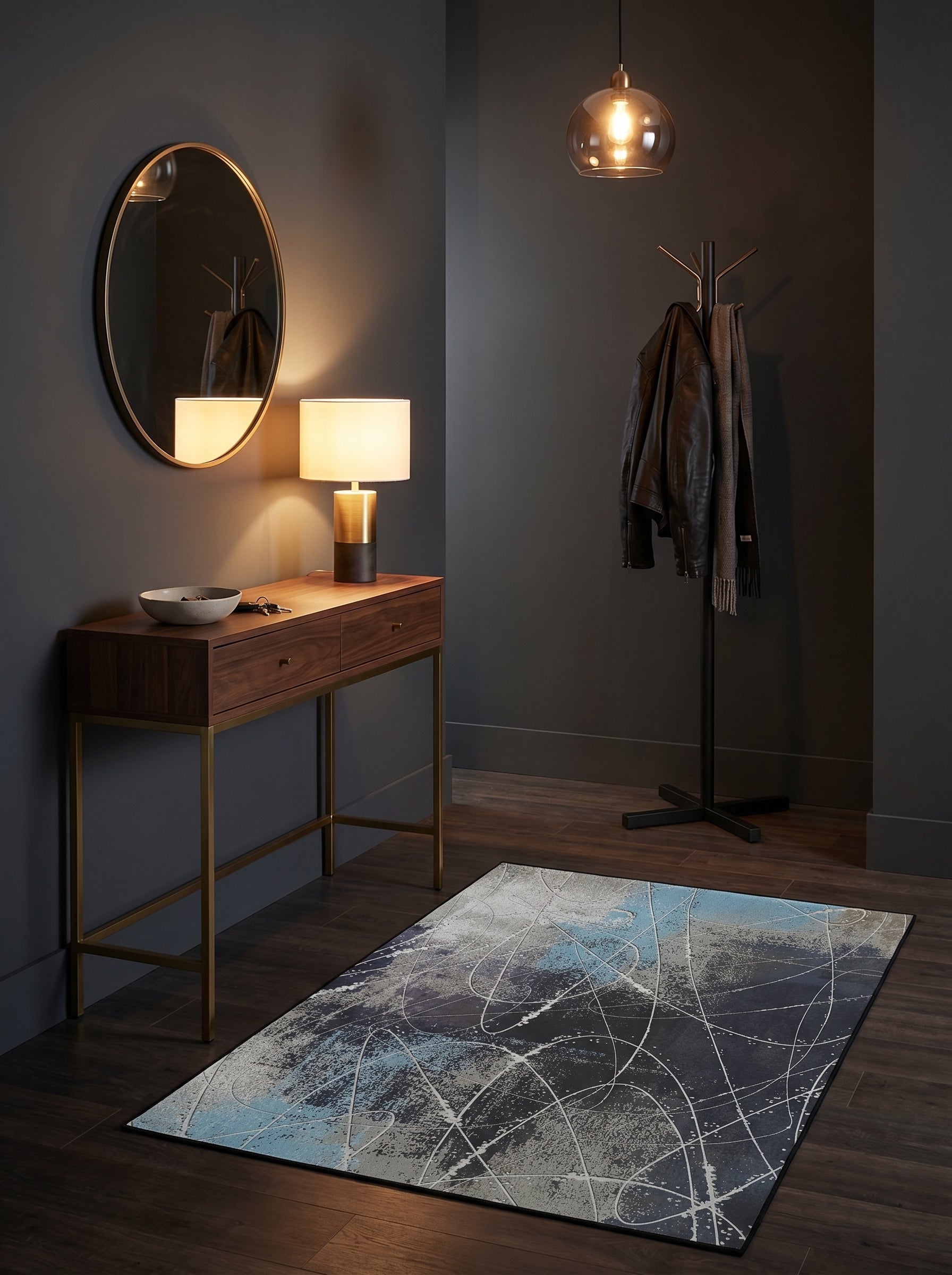 Tapis rectangulaire aux motifs abstraits d'éclaboussures bleues et grises et de fines lignes blanches sur fond sombre, dans une entrée