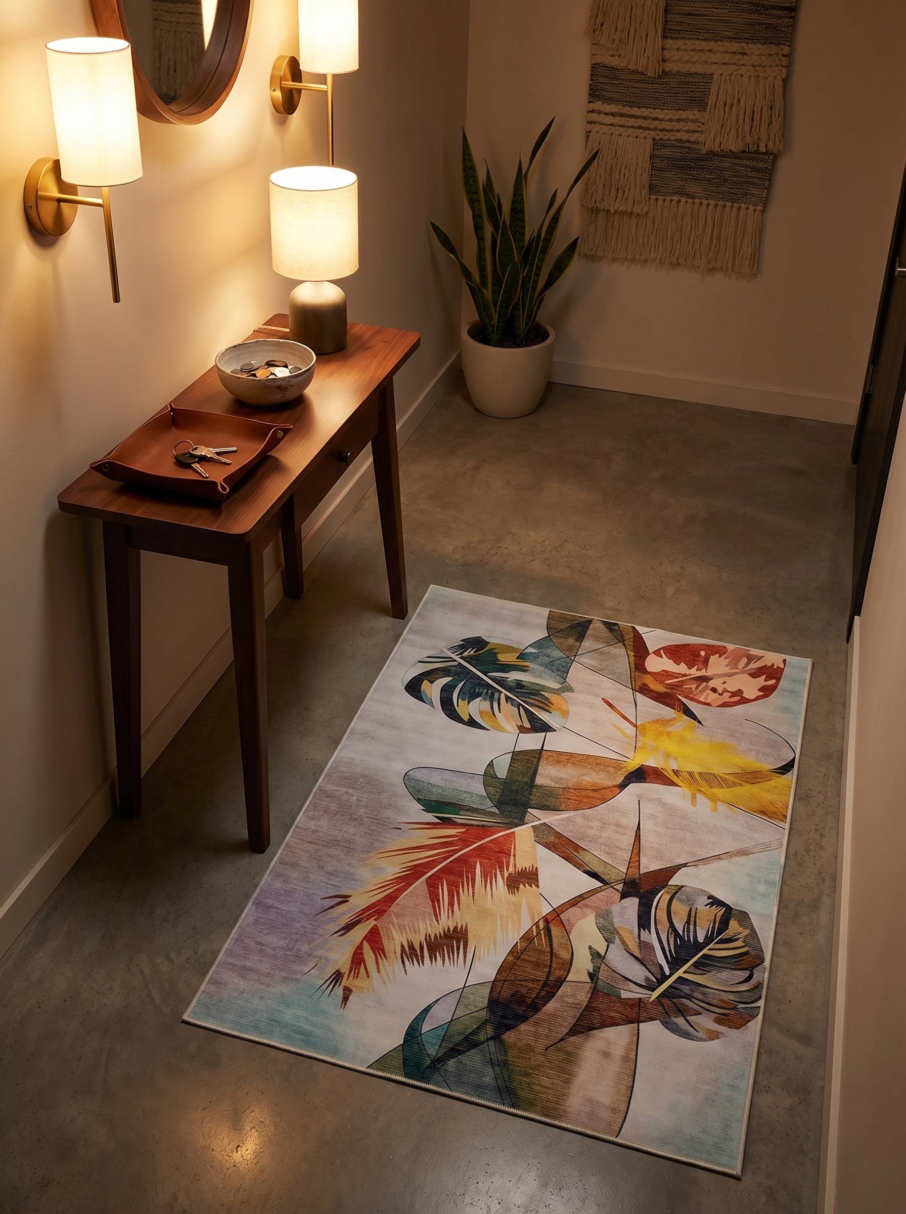 Tapis rectangulaire aux motifs abstraits de feuilles tropicales et formes géométriques, mêlant jaune, orange, bleu canard et violet sur un fond clair, posé sur le sol en béton d'une entrée moderne