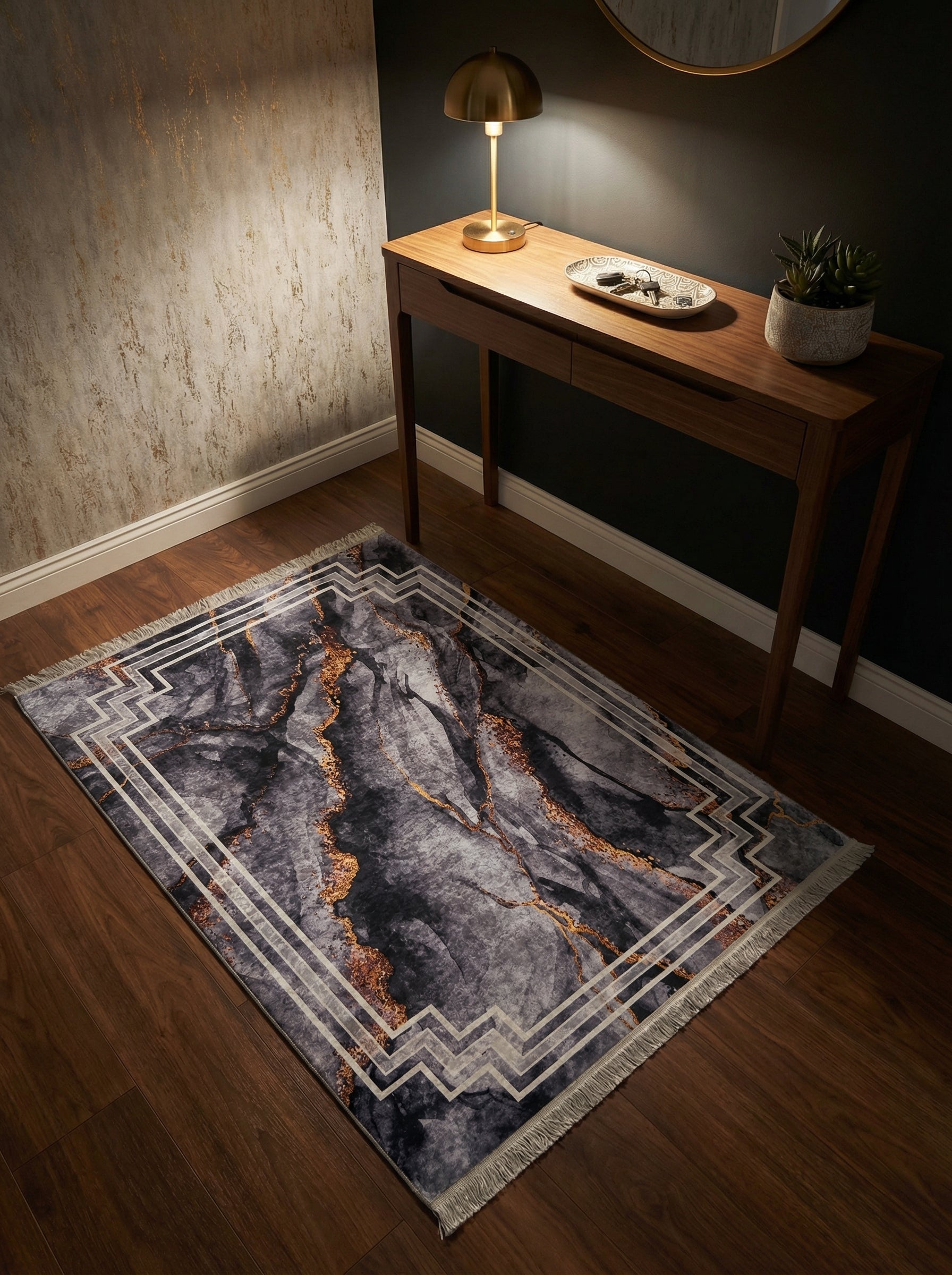Tapis rectangulaire gris anthracite marbré de doré, avec une bordure géométrique blanche, sur un parquet dans une entrée
