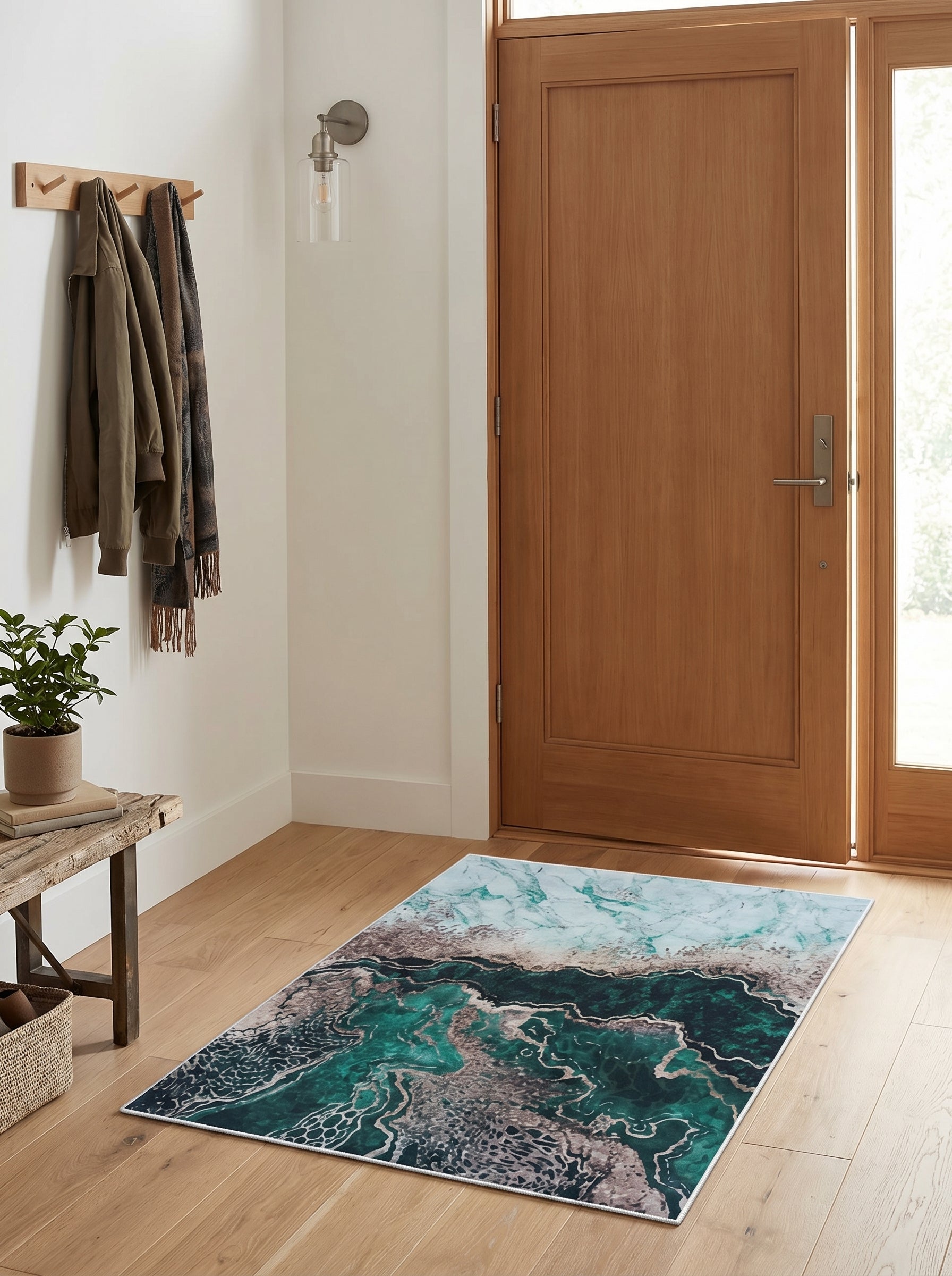 Tapis rectangulaire aux motifs abstraits marbrés de vert émeraude, turquoise et gris, couvrant le sol d'une entrée lumineuse