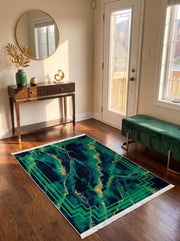 Tapis rectangulaire marbré vert émeraude, bleu marine et or, avec une bordure géométrique verte et des franges blanches, sur un plancher en bois dans une entrée