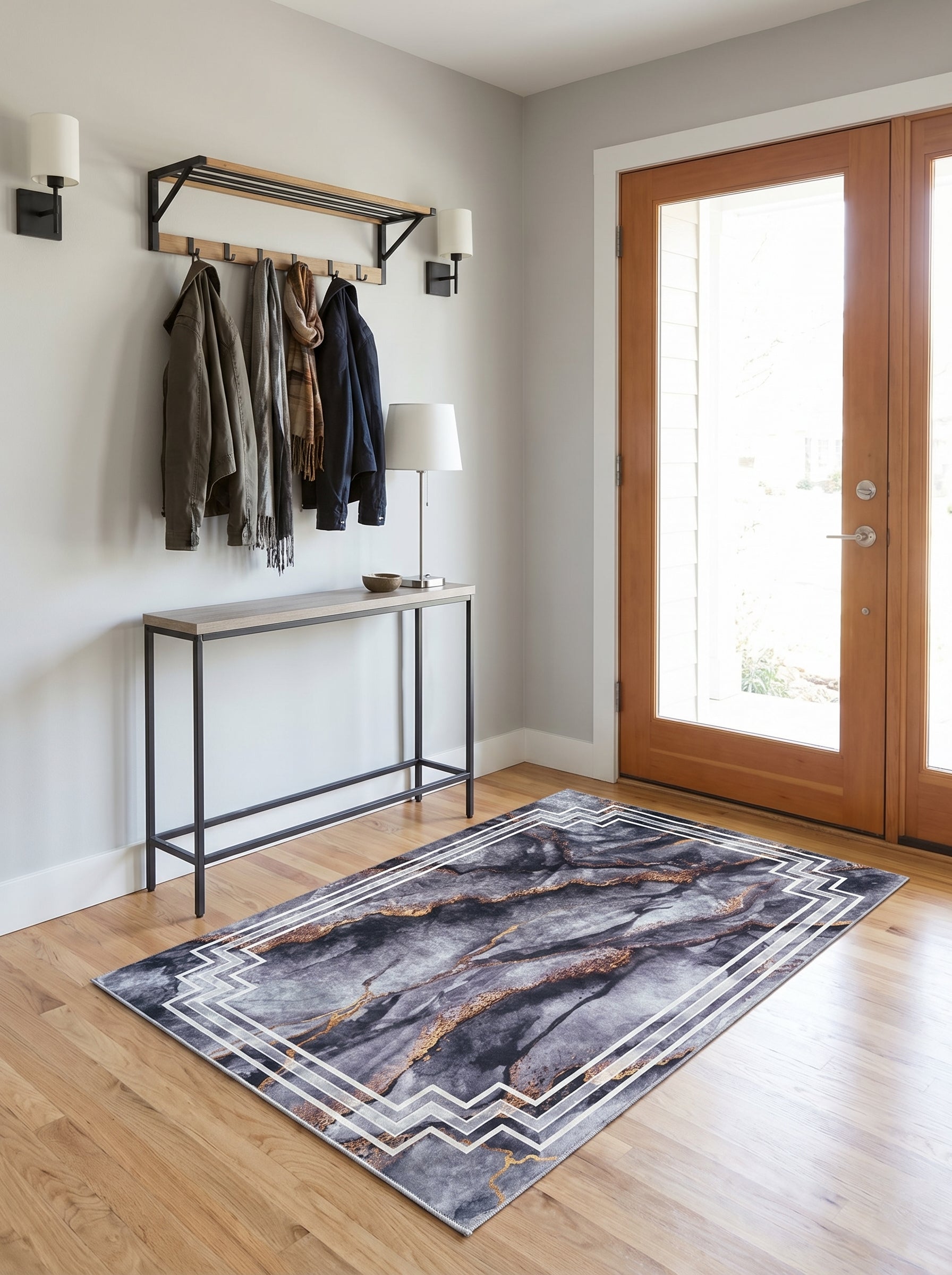 Tapis rectangulaire gris foncé à motif de marbre or et blanc géométrique, posé sur un parquet dans une entrée moderne