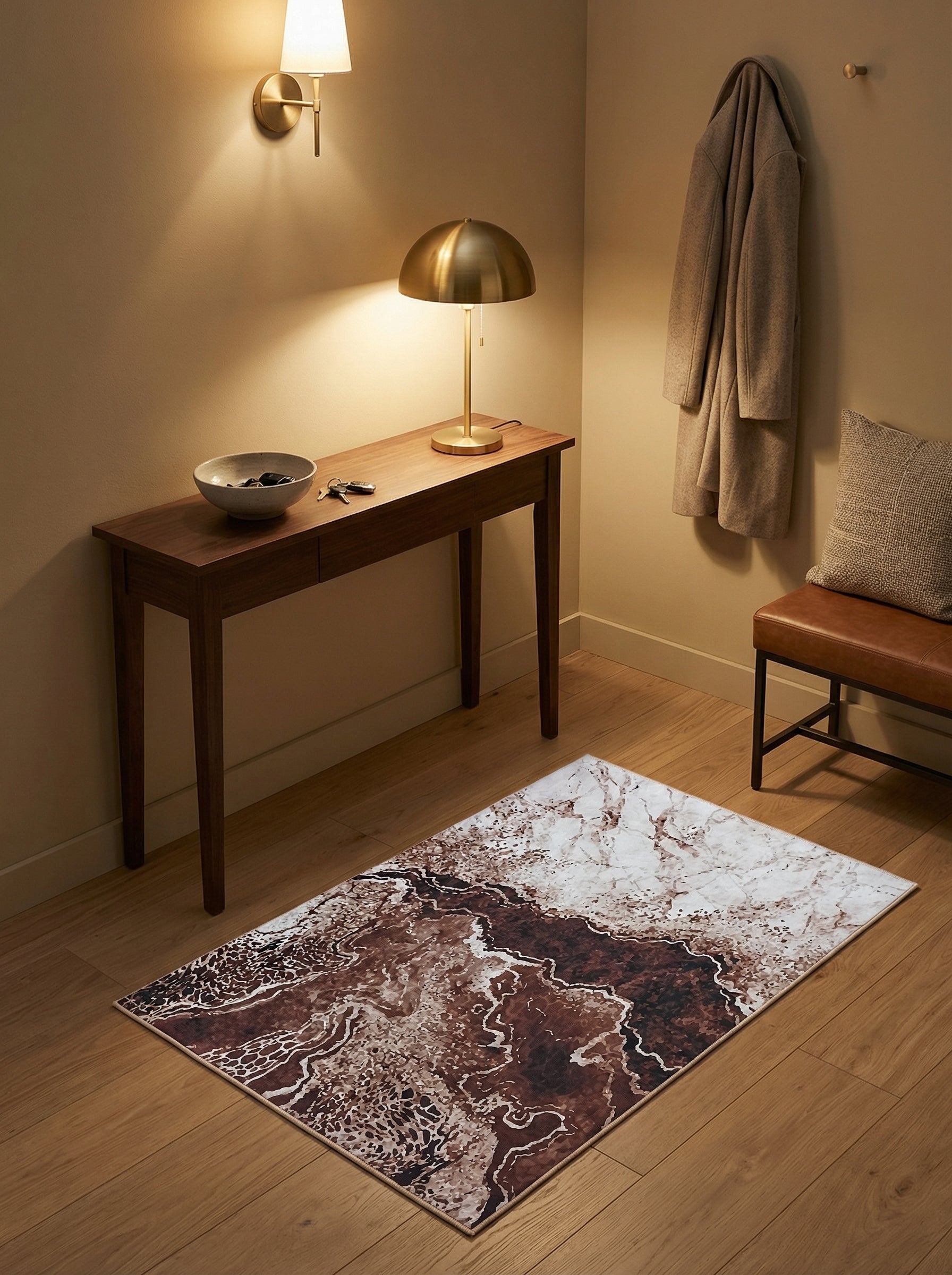 Tapis rectangulaire aux motifs abstraits marron et blanc crème évoquant des veines de roche ou de marbre, posé sur un parquet clair dans une entrée accueillante