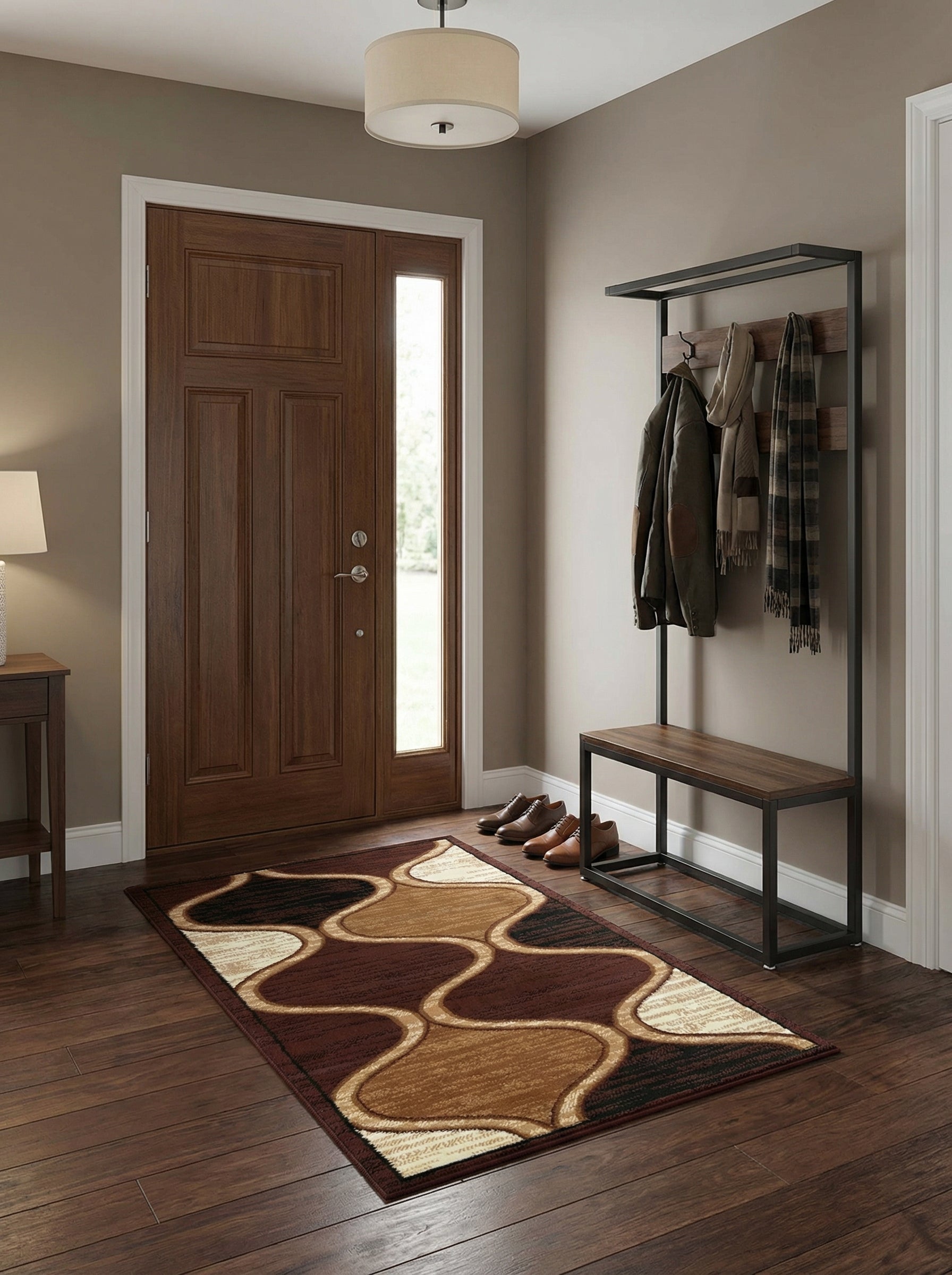 Tapis rectangulaire à motifs ondulés marron foncé, marron clair, beige et noir posé sur un parquet dans une entrée