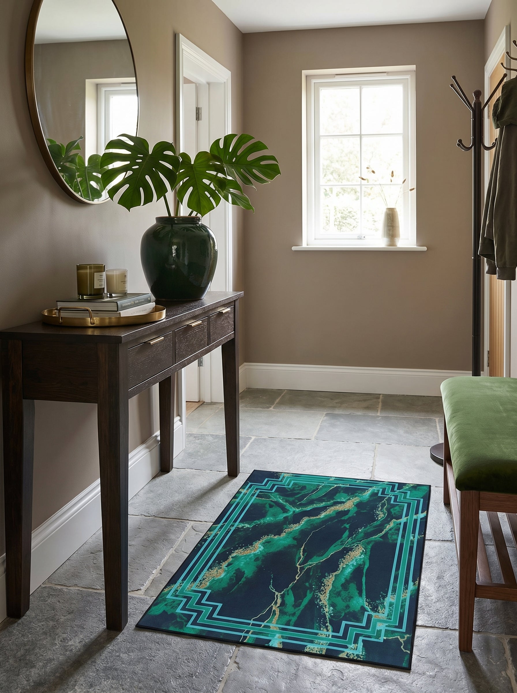 Tapis rectangulaire bleu-vert marbré de doré, avec une bordure géométrique verte, posé sur le sol d'une entrée