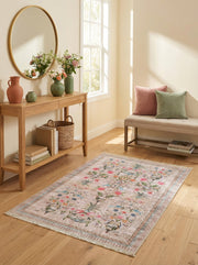 Tapis rectangulaire beige rosé à motifs floraux et oiseaux multicolores vifs, bordure rayée, sur parquet clair dans une entrée
