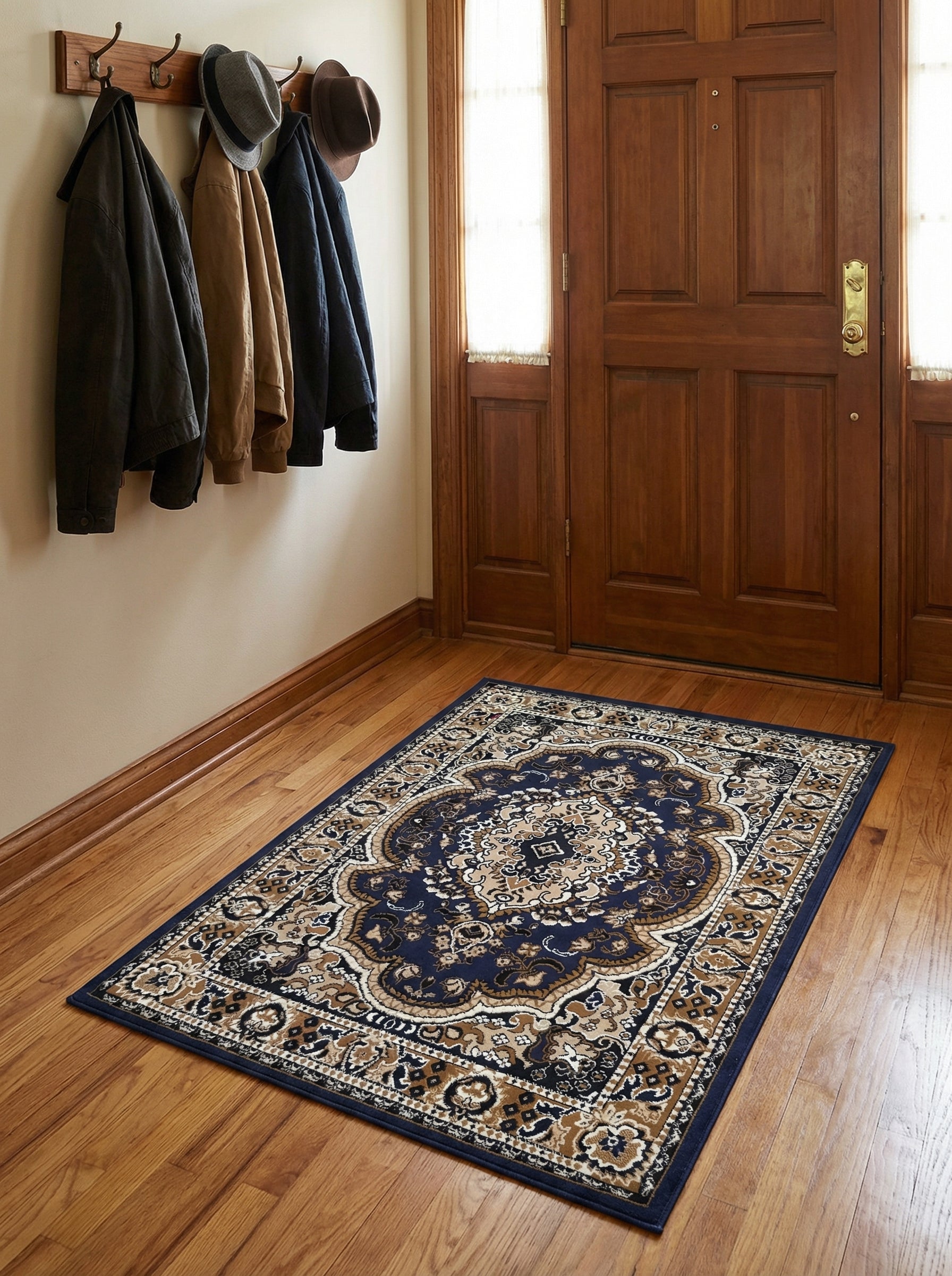 Tapis rectangulaire bleu foncé à motifs orientaux beiges, blancs et noirs, posé sur un parquet clair dans une entrée