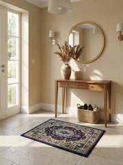 Tapis rectangulaire bleu marine aux motifs floraux et arabesques beiges, blancs et or dans une entrée