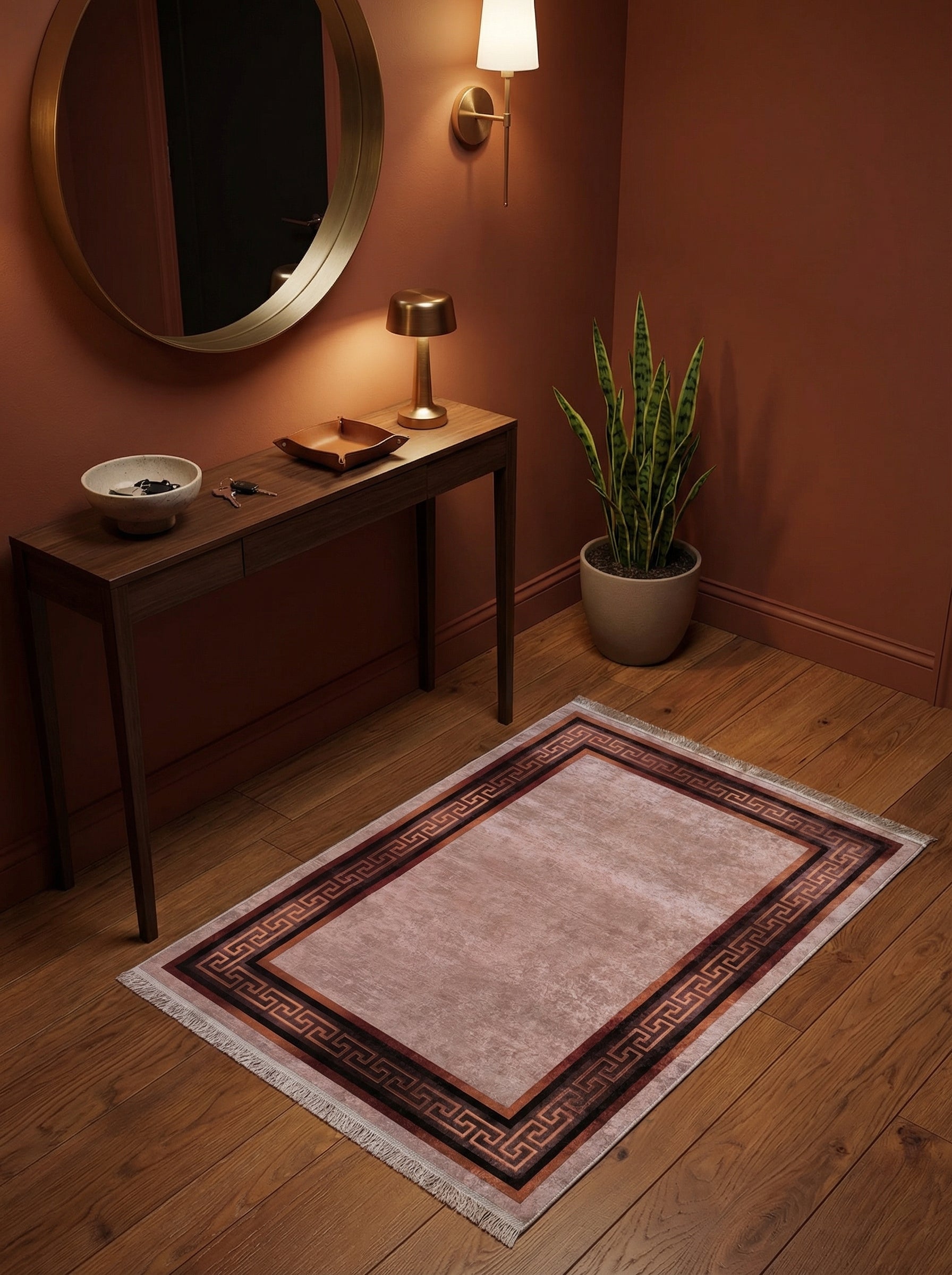 Tapis rectangulaire rosé à motifs méandre géométriques marron et cuivre en bordure, posé sur parquet dans une entrée