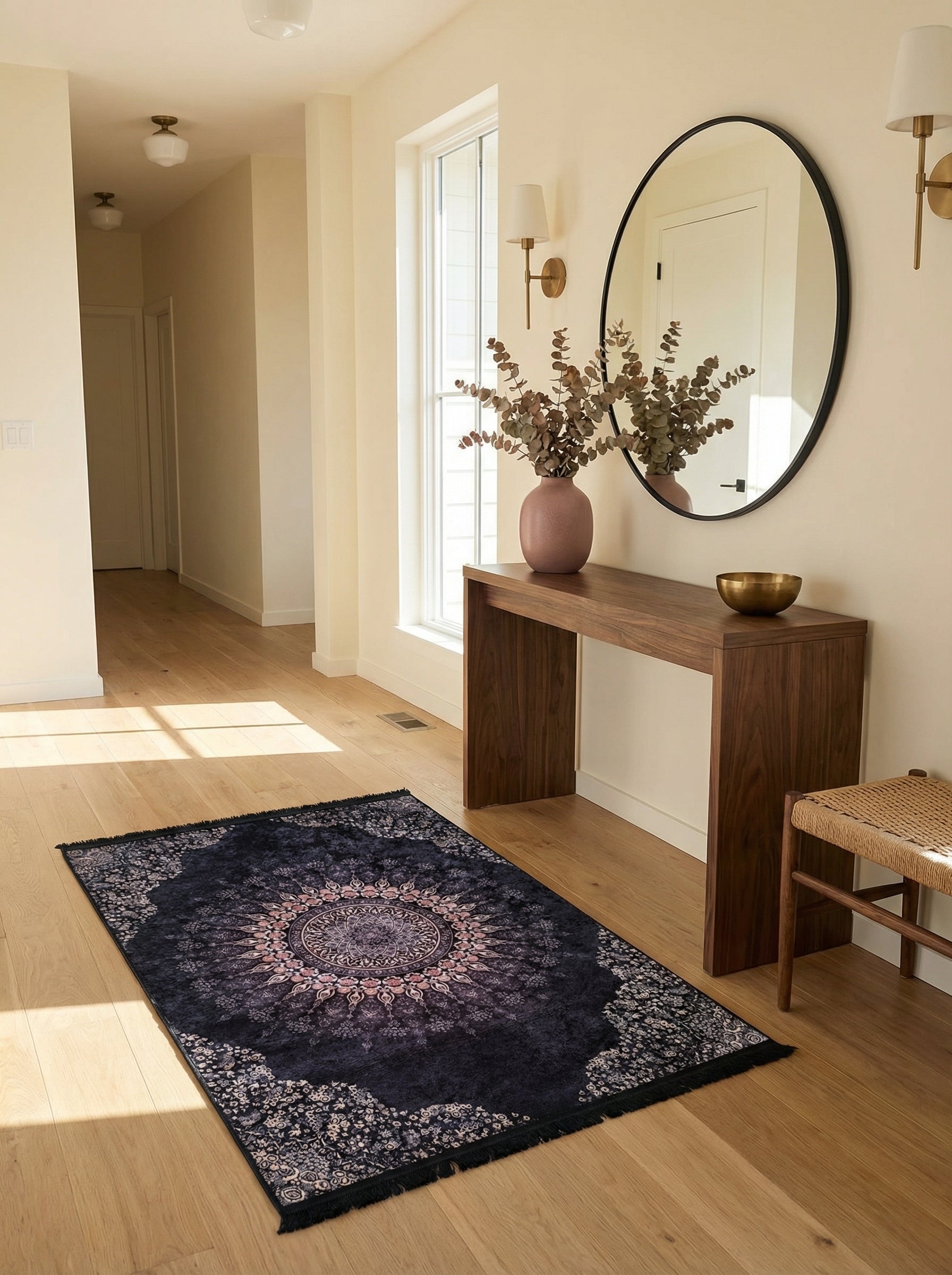 Tapis rectangulaire bleu foncé à motifs floraux et mandalas roses et gris, posé sur un parquet clair dans une entrée lumineuse