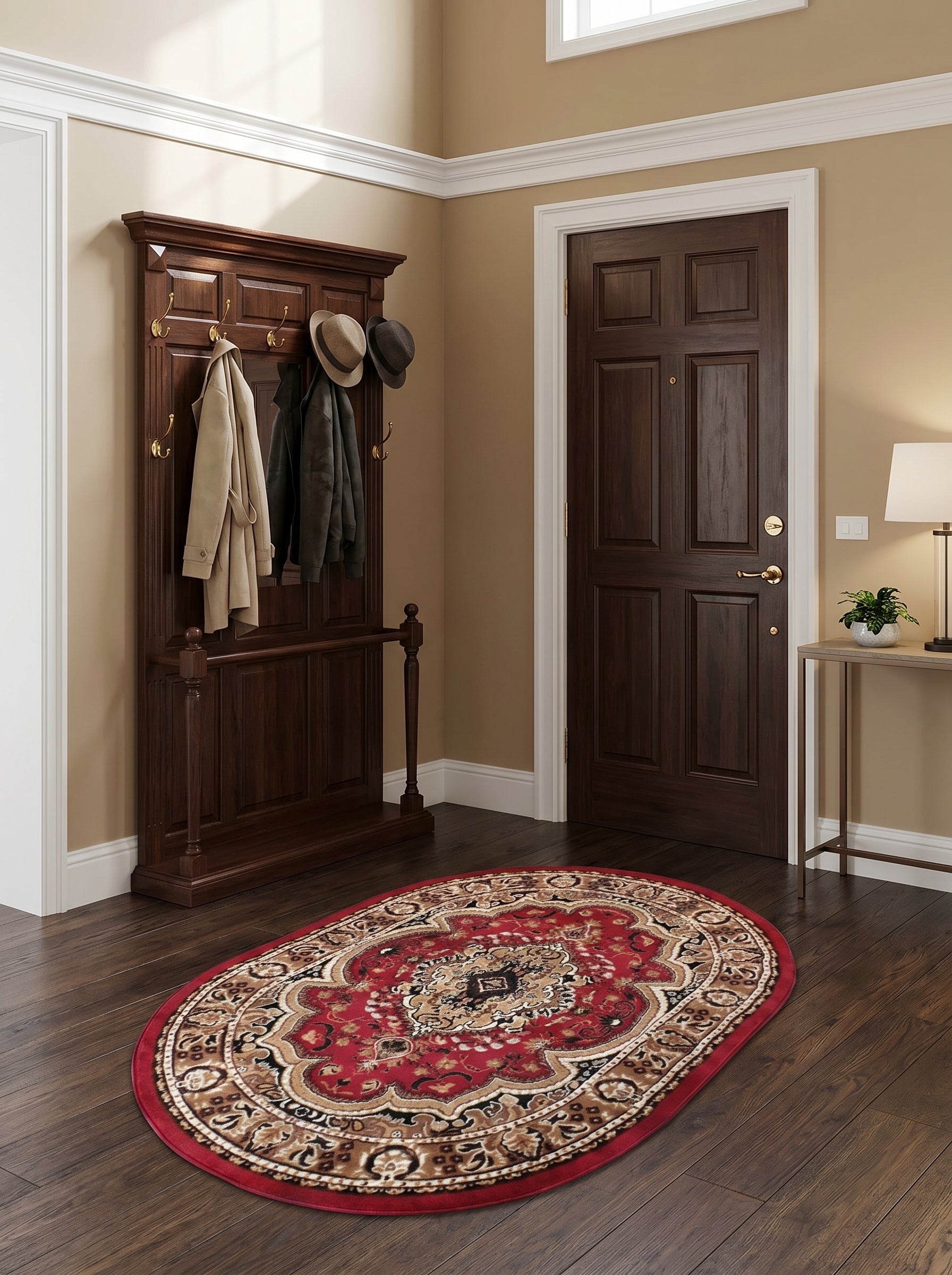 Tapis ovale rouge orné de motifs orientaux beiges, marrons et noirs, posé sur un parquet dans une entrée élégante