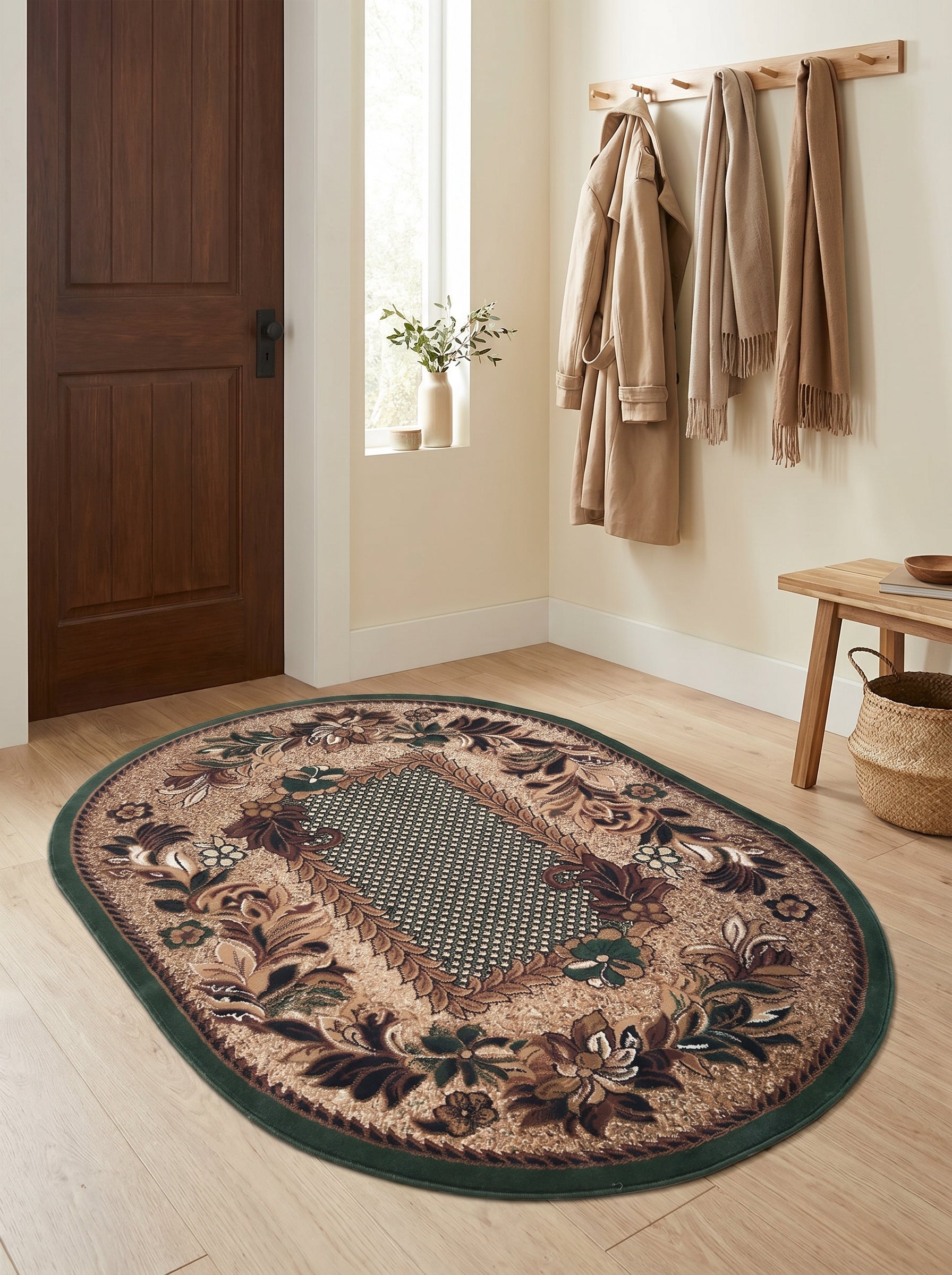 Tapis ovale à motifs floraux beiges, marron et verts, avec une bordure vert foncé, posé sur un parquet clair dans une entrée