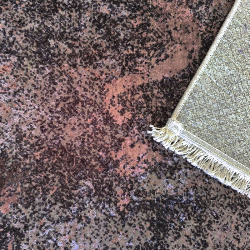 Tapis velouté aux motifs abstraits sombres marron-rouge. Une frange crème et l'envers texturé du tapis sont visibles