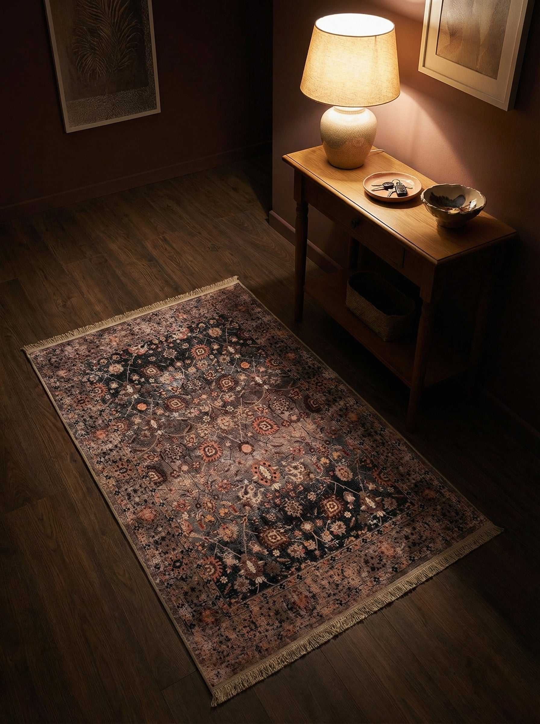 Tapis d'aspect vieilli aux motifs floraux complexes bleu nuit, terracotta et beige, à franges, sur un parquet foncé dans une entrée