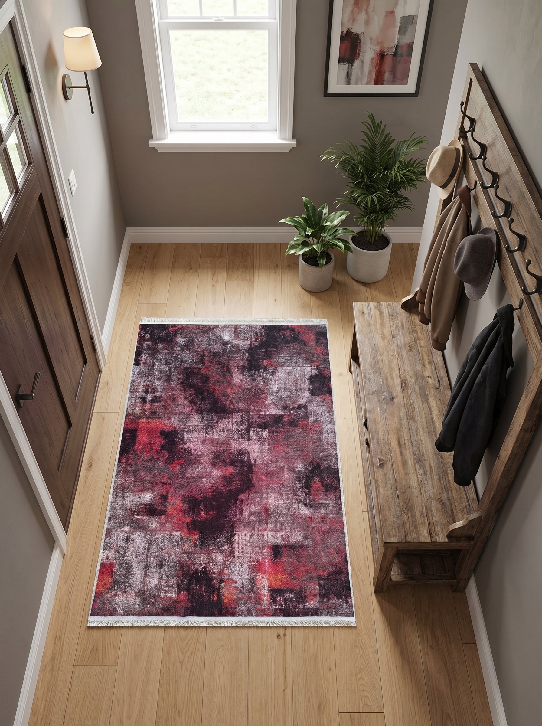 Tapis rectangulaire abstrait aux teintes bordeaux, noir et gris clair effet vieilli, avec franges, dans un hall d'entrée