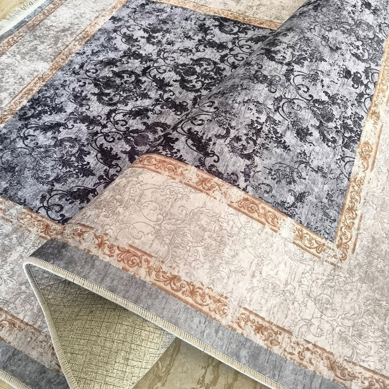 Tapis aux motifs ornementaux. Le premier est gris à motifs noirs, le second, roulé, est beige clair avec des bordures brunes