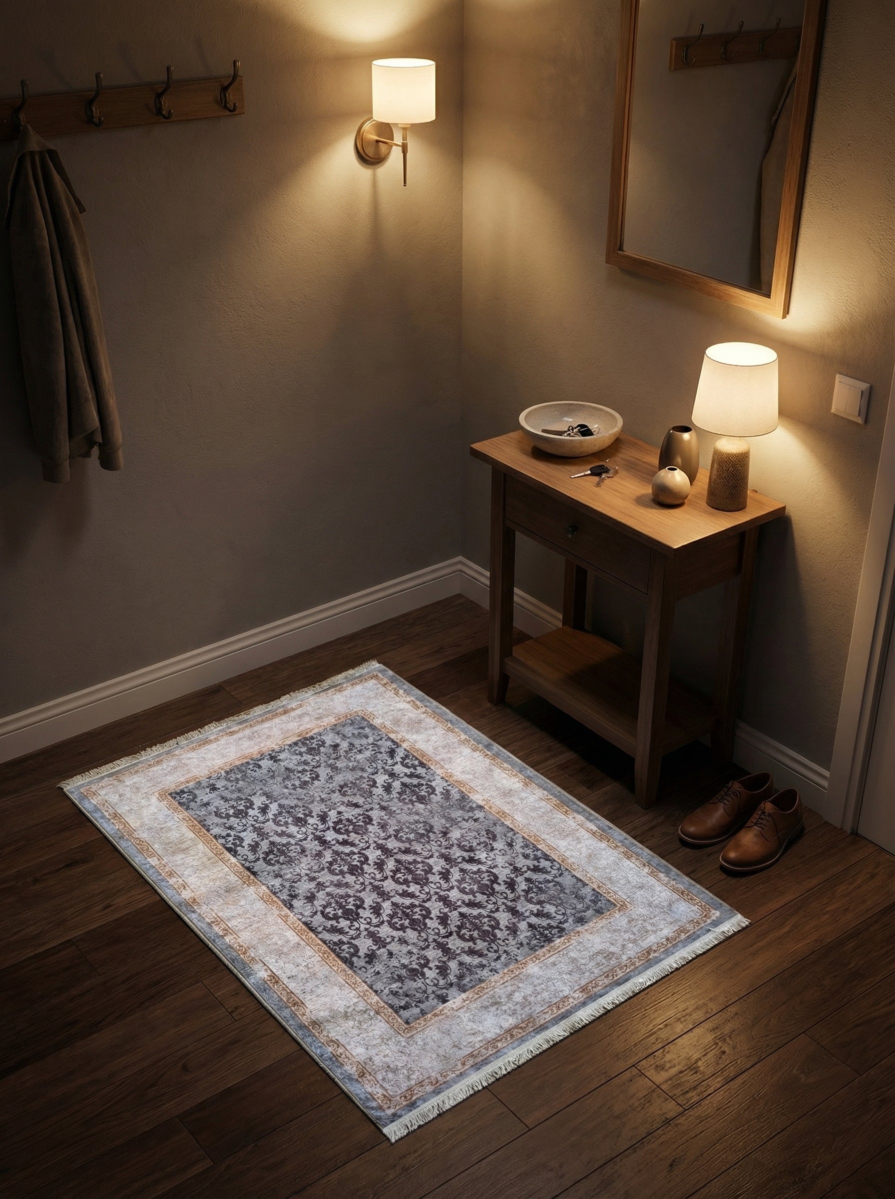 Tapis rectangulaire à motifs floraux gris-bleu délavés et pourpre, bordure crème vieillie à franges, sur parquet dans une entrée cosy