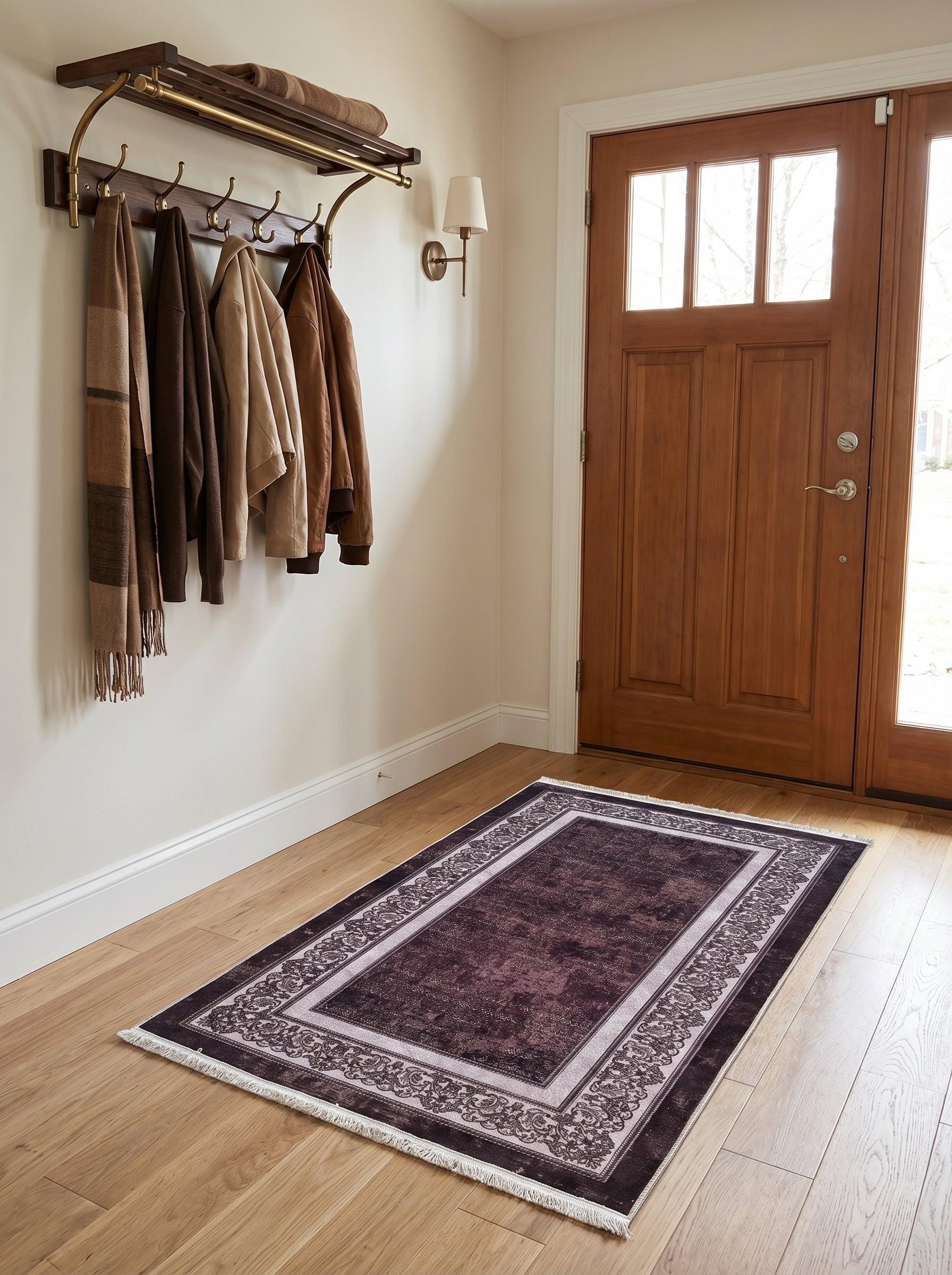 Tapis rectangulaire violet foncé vieilli, bordure crème à motifs baroques sombres et franges, sur parquet clair dans une entrée