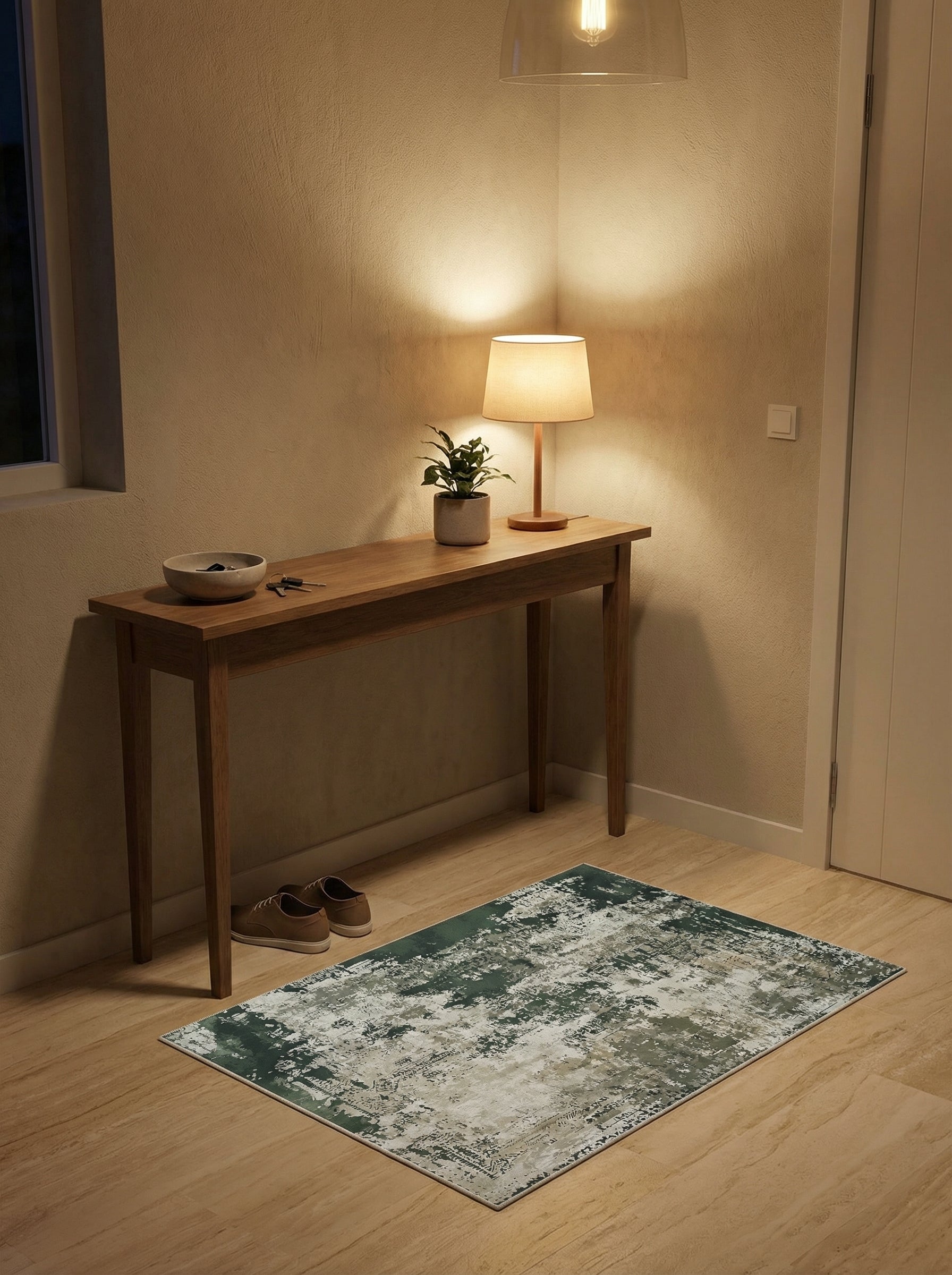 Tapis rectangulaire aux motifs abstraits vert foncé, blanc cassé et beige clair sur un parquet, dans une entrée
