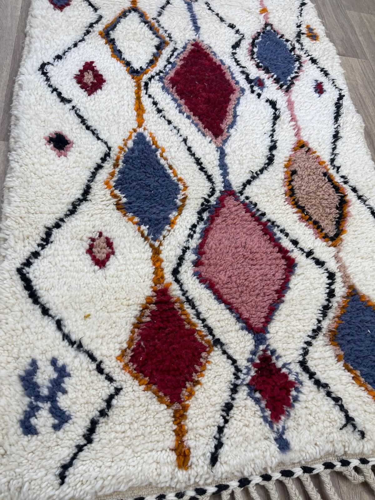 Gros plan sur la laine du tapis d'escalier berbère Anaruz, laine de mouton au poil long, blanc multicolore
