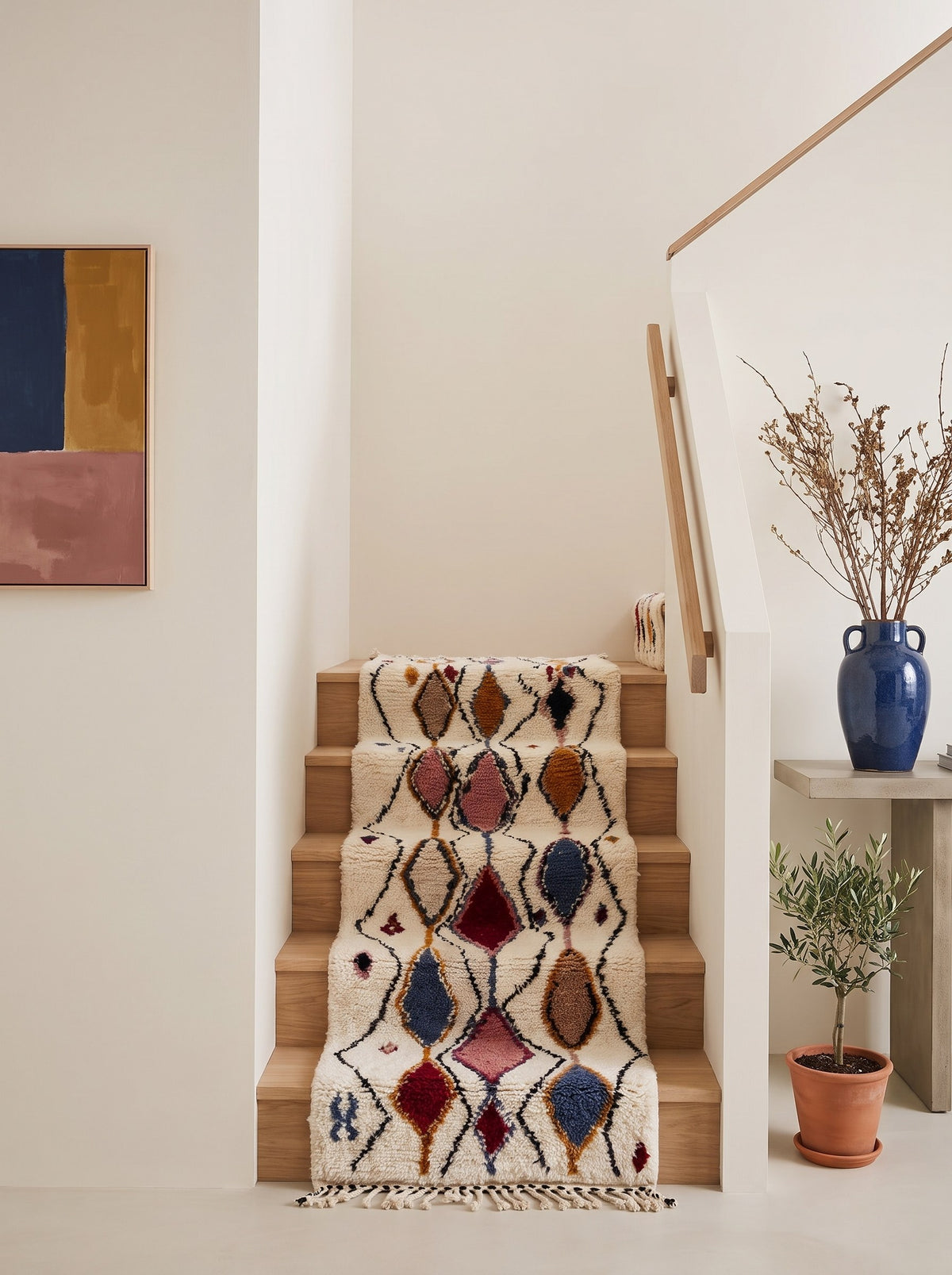 Tapis d'escalier berbère à losanges blanc multicolore Anaruz sur un autre escalier, noué main au Maroc