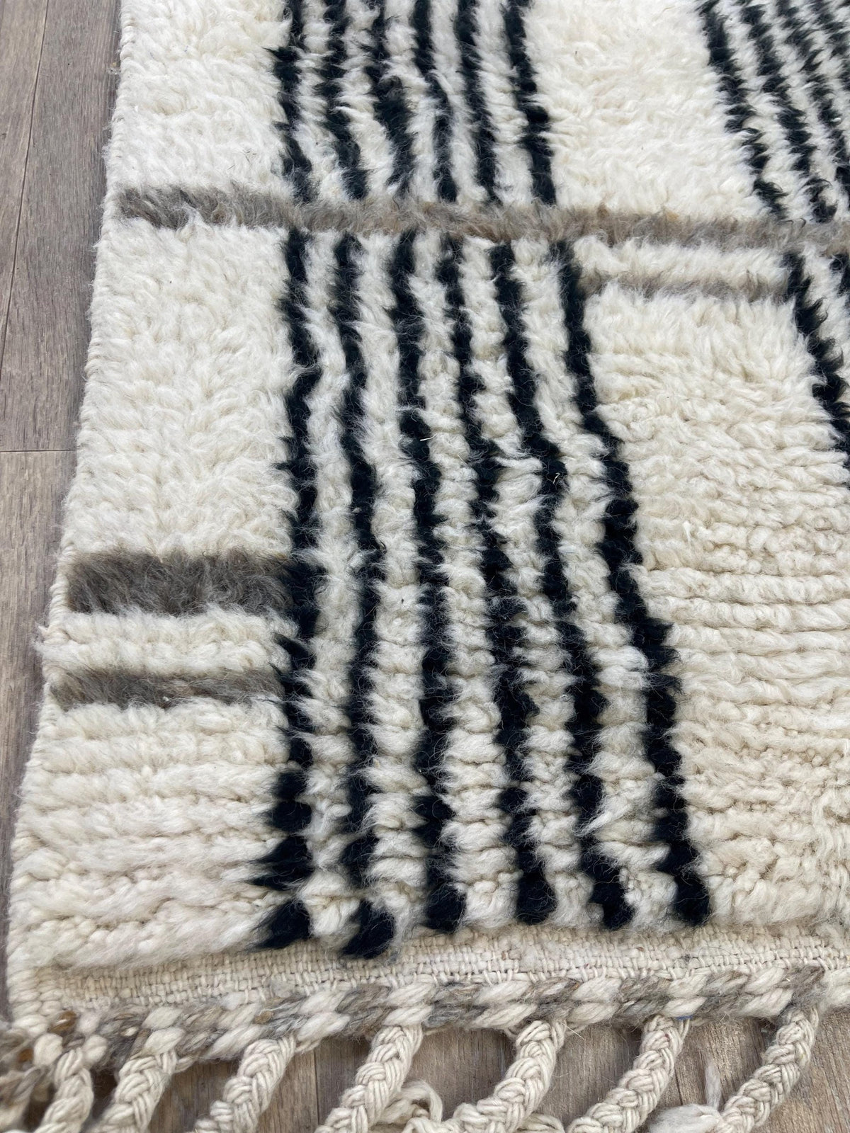 Gros plan sur le coin relevé du tapis d'escalier berbère Aknoul, épaisseur du poil long et dos tissé à la main