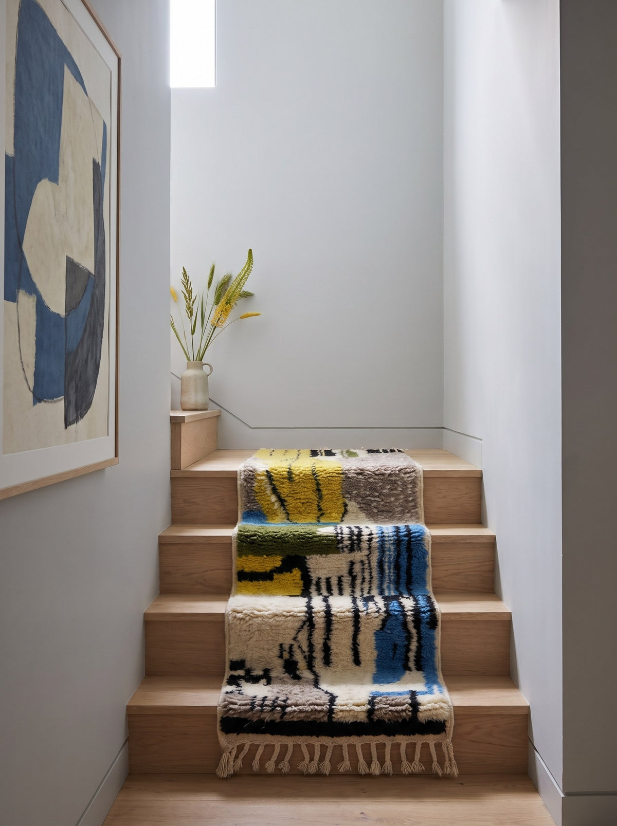 Tapis d'escalier berbère coloré jaune et bleu Iznagal sur un autre escalier, noué main au Maroc