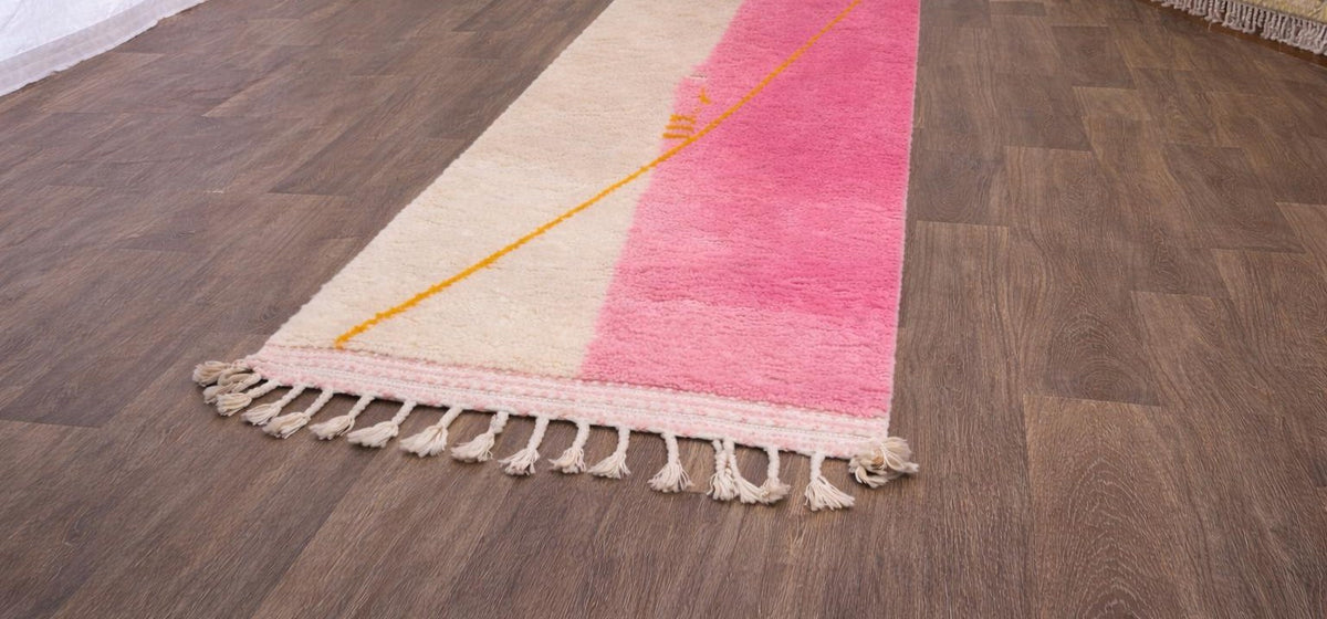 Tapis d'escalier berbère coloré rose et blanc Tanmila posé au sol vu de trois quarts, noué main au Maroc