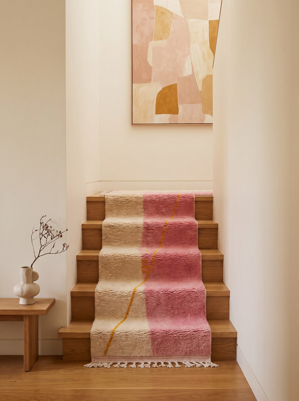 Tapis d'escalier berbère coloré rose et blanc Tanmila sur un escalier, noué main au Maroc