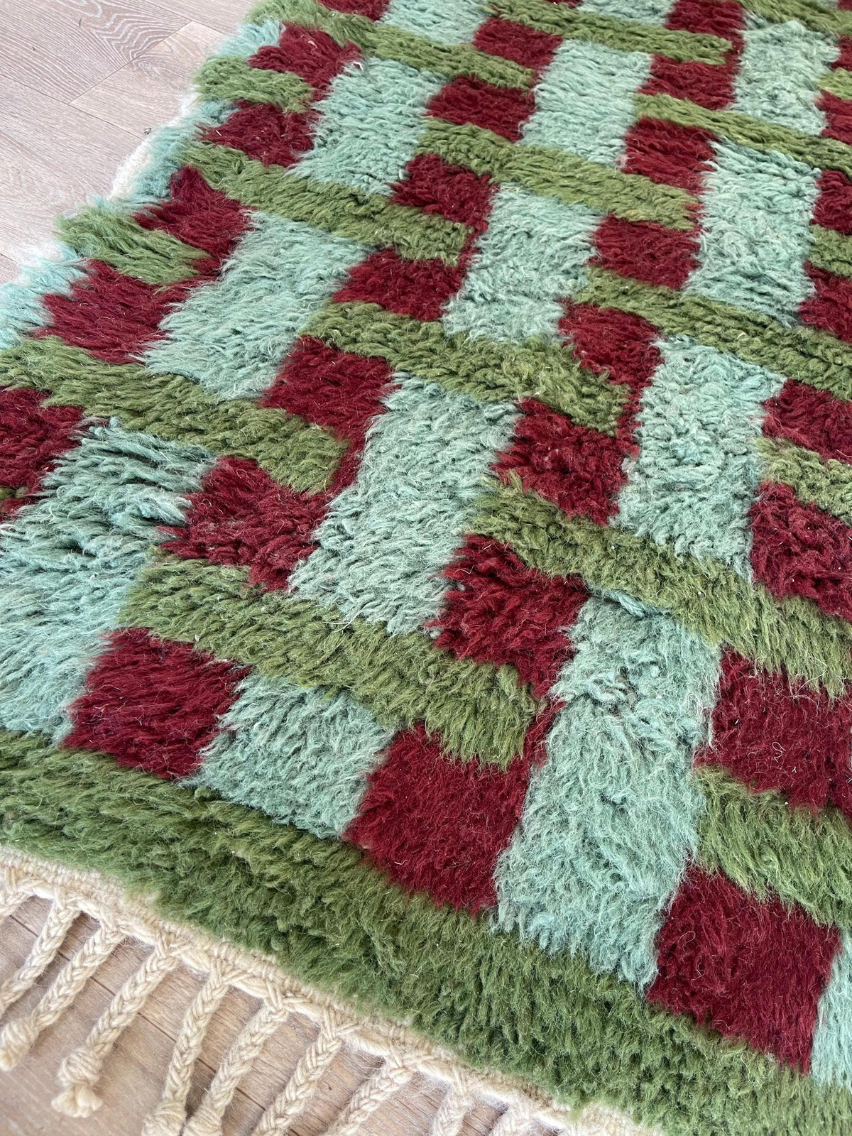 Gros plan sur le coin relevé du tapis d'escalier berbère Oualidia, épaisseur du poil long et dos tissé à la main
