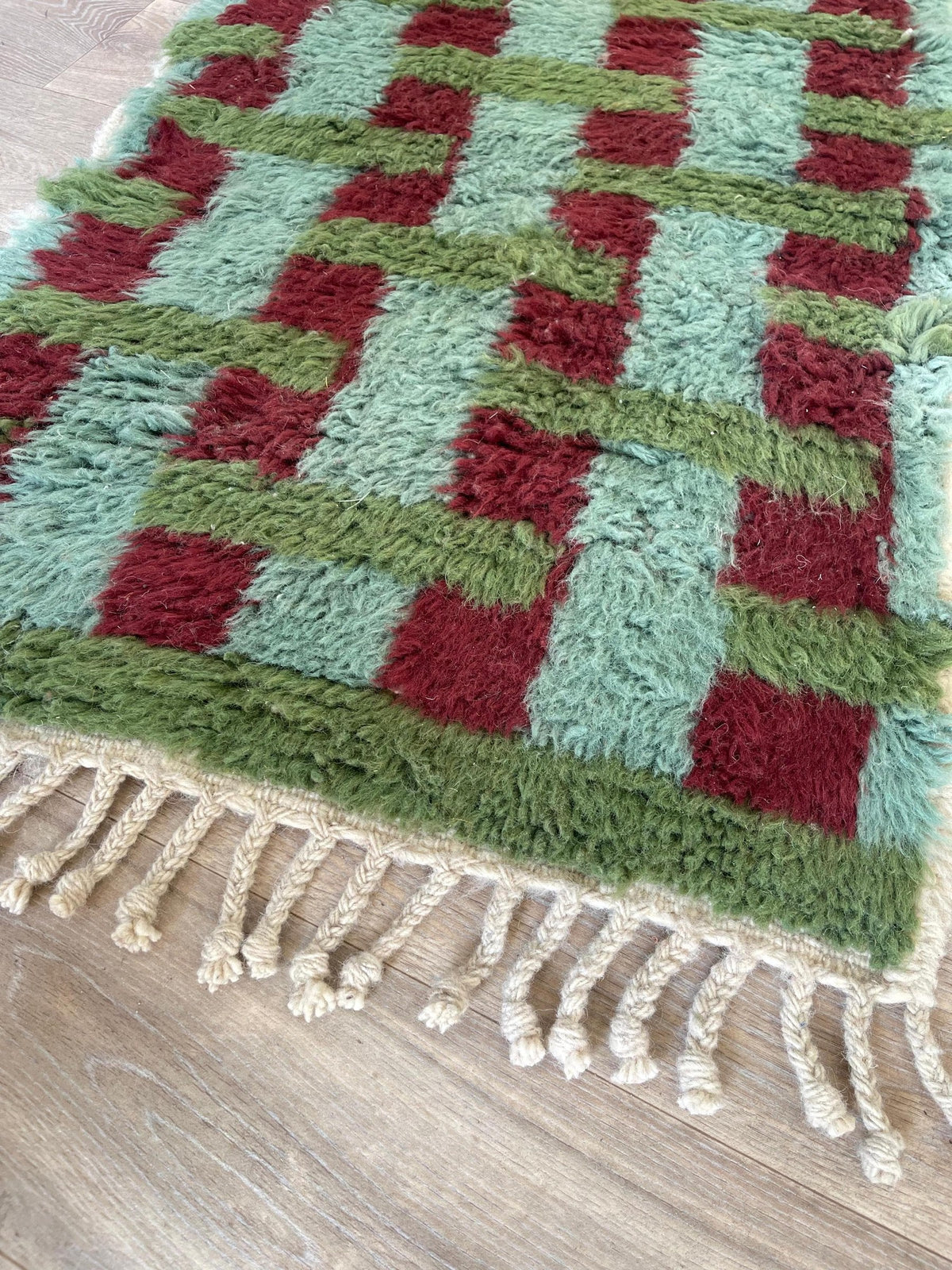 Gros plan sur les franges du tapis d'escalier berbère Oualidia, écrues à pompons en bas seulement, nouées à la main