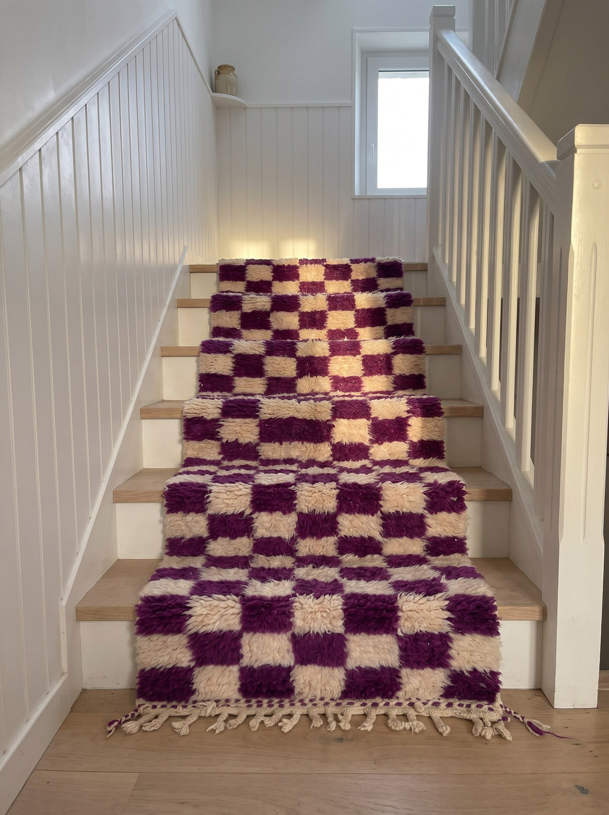 Zerrouka Berber stair runner with a purple checkerboard pattern, on a staircase, hand-knotted in Morocco