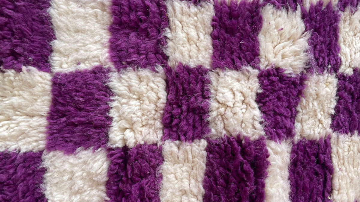 Gros plan sur la laine du tapis d'escalier berbère Zerrouka, poil violet noué à la main