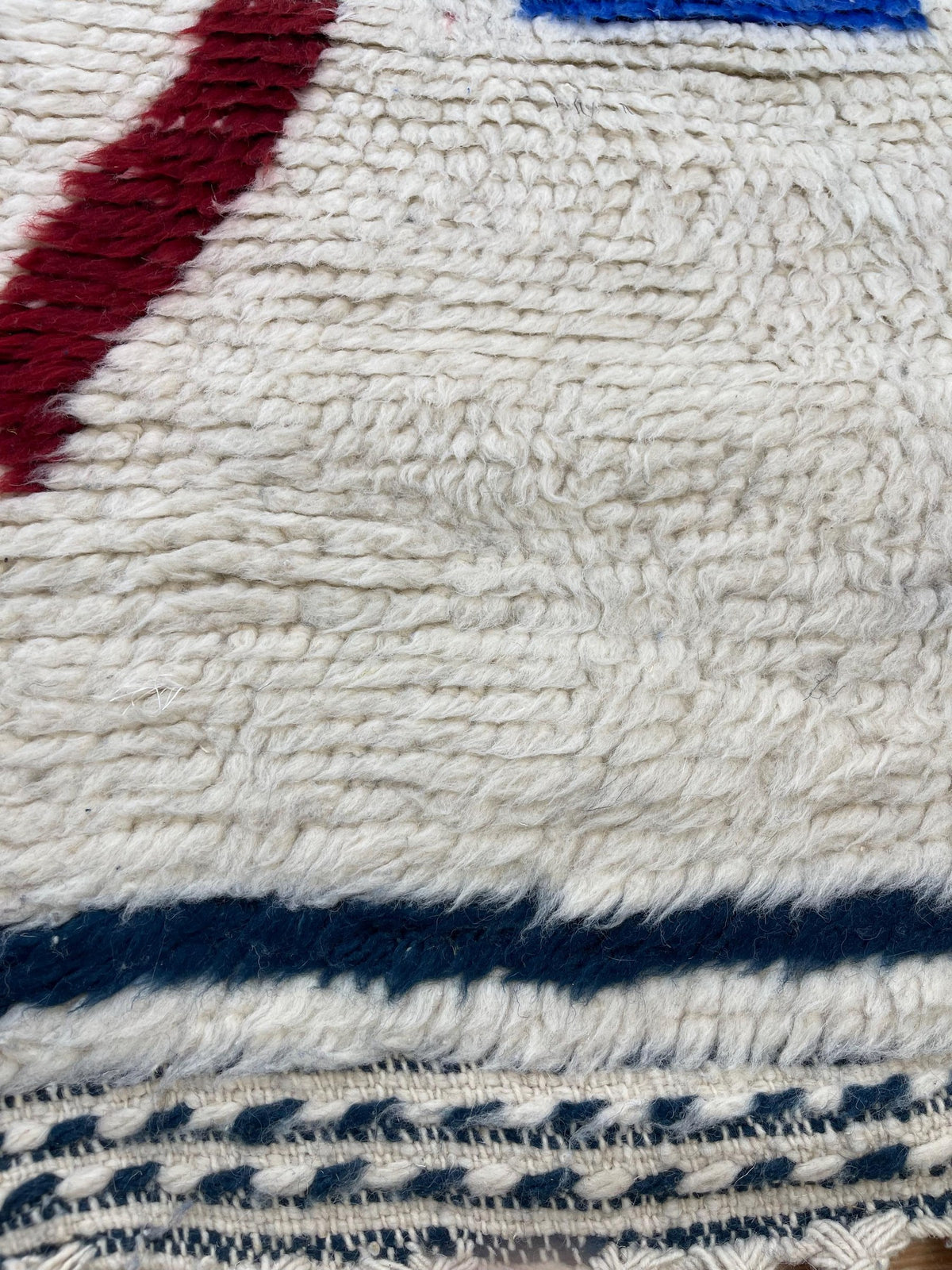 Gros plan sur la laine du tapis d'escalier berbère Bouregreg, nœuds serrés et tracé du motif de près