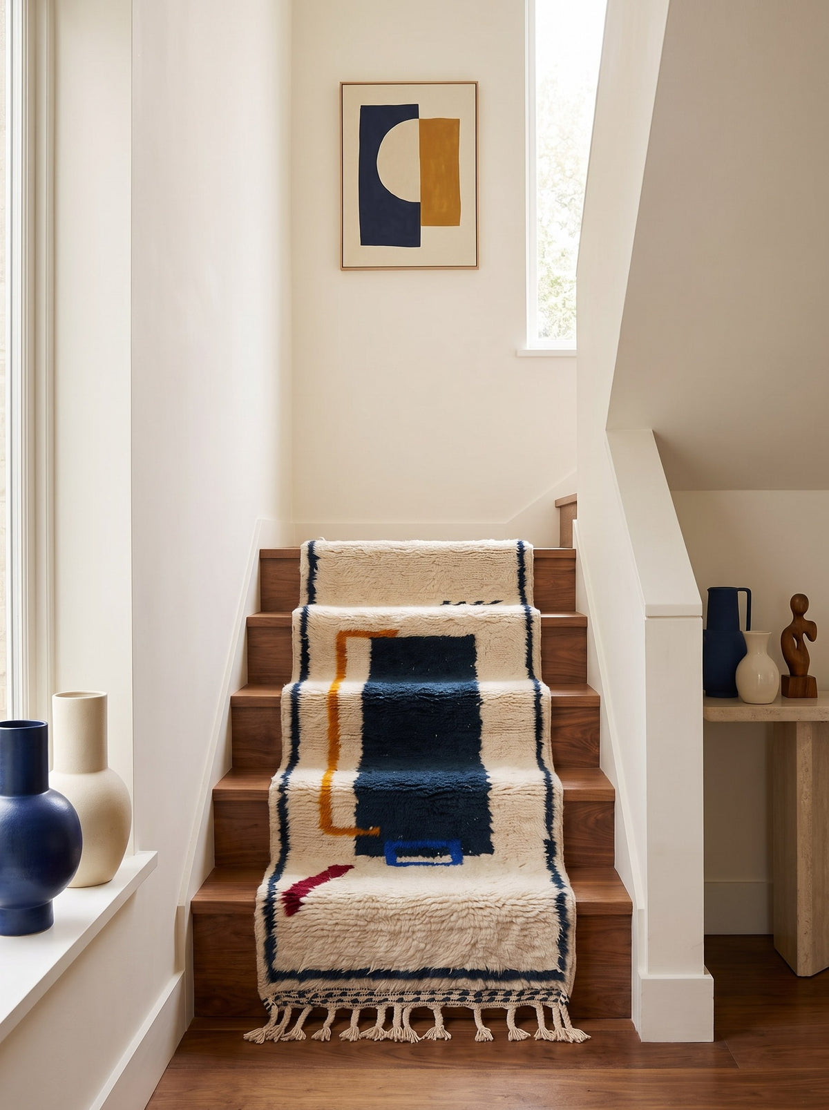 Tapis d'escalier berbère graphique blanc et bleu Bouregreg sur un troisième escalier, noué main au Maroc