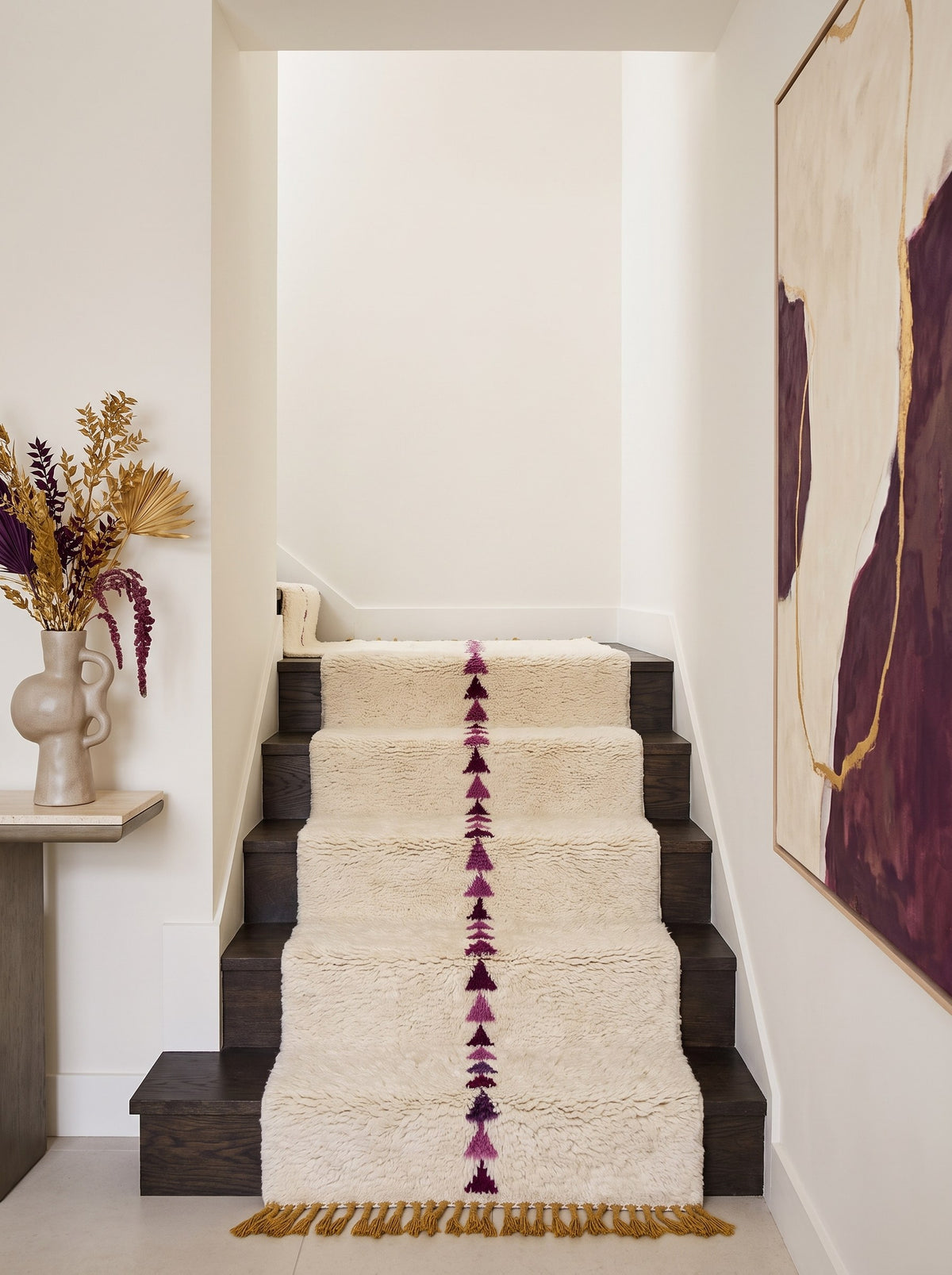 Tapis d'escalier berbère graphique blanc et prune Anir sur un troisième escalier, noué main au Maroc