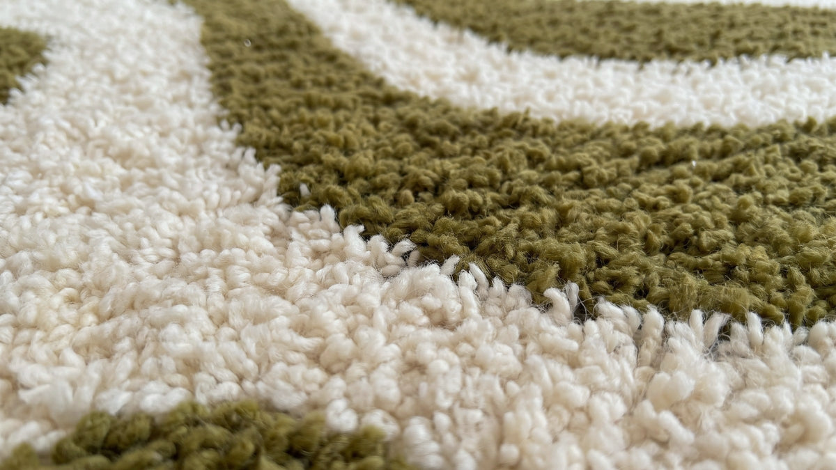 Gros plan sur la laine du tapis d'escalier berbère Assaka, poil blanc et vert olive