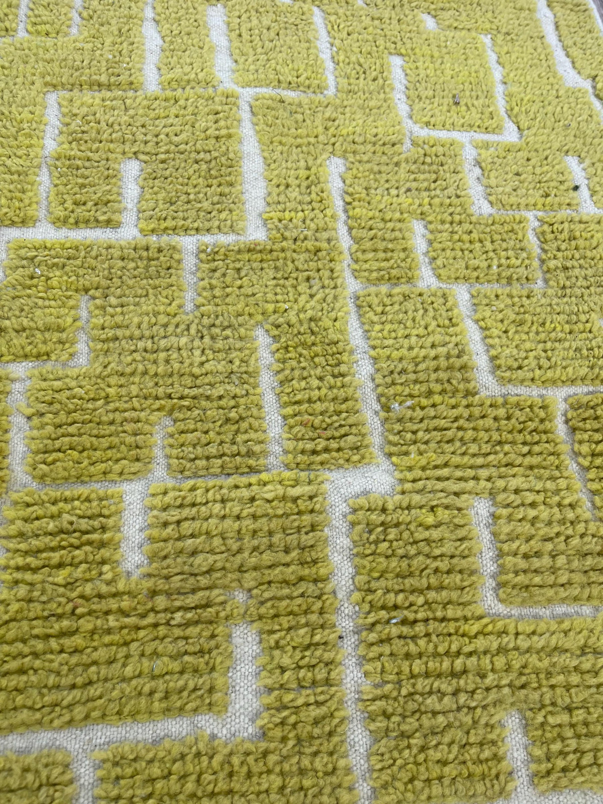 Gros plan sur la laine du tapis d'escalier berbère Timzin, laine de mouton au poil ras, jaune moutarde