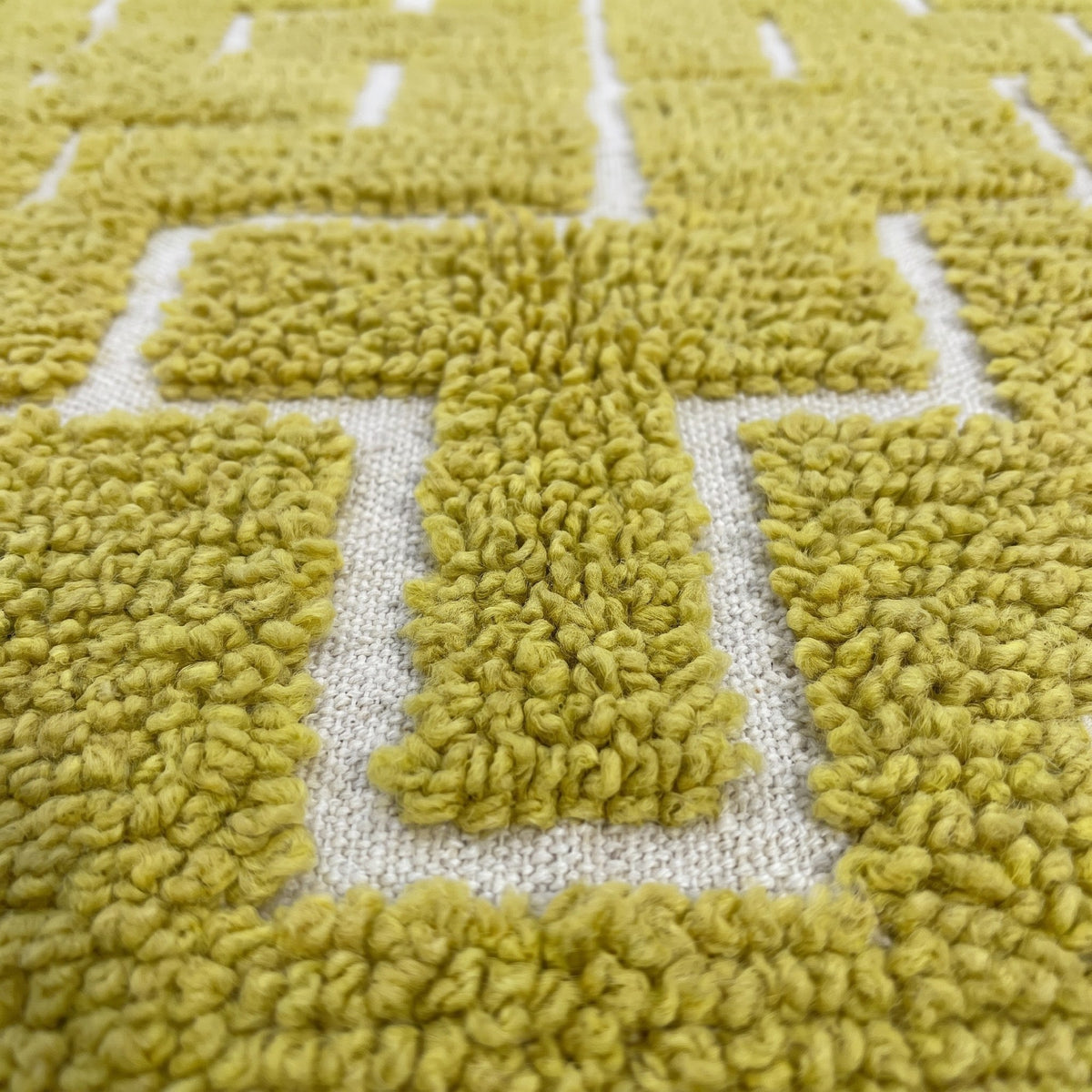 Gros plan sur un motif du tapis d'escalier berbère Timzin, couloir jaune moutarde à poil ras bouclé