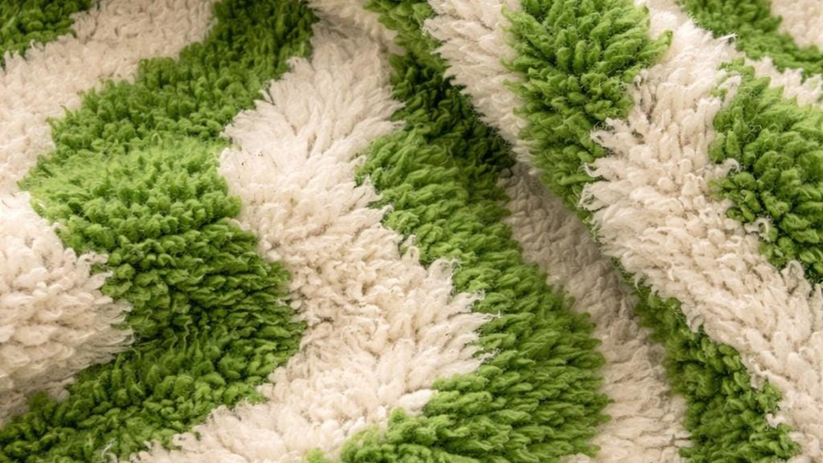 Gros plan sur la laine du tapis d'escalier berbère Ouzoud, poil vert et blanc noué à la main