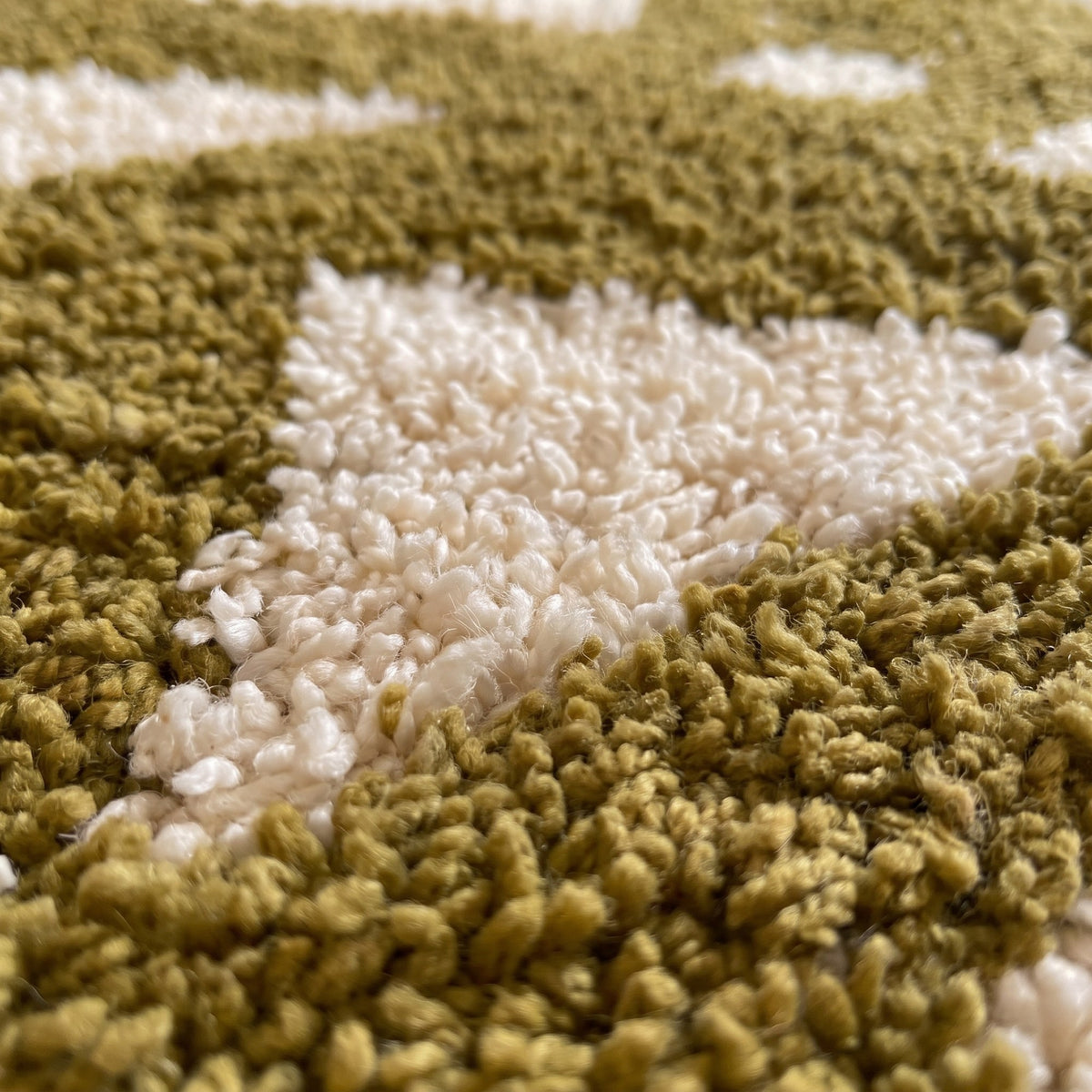 Gros plan sur un motif du tapis d'escalier berbère Azelt, couloir vert olive à poil long