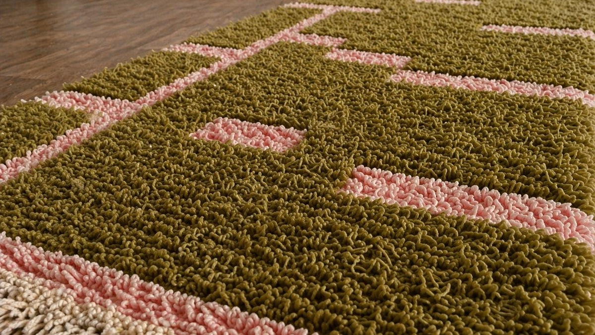 Gros plan sur la laine du tapis d'escalier berbère Bougmez, poil vert olive et rose