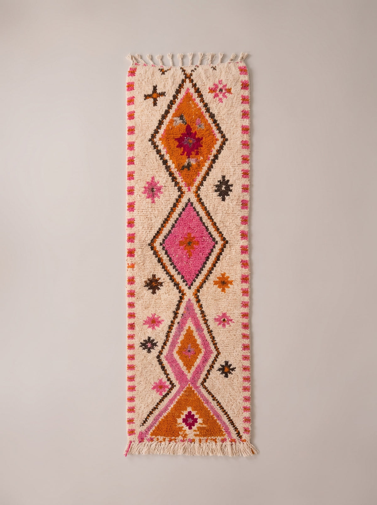 Tifawin Berber stair runner, Azilal style, in white, orange and pink, laid flat, ecru runner, an orange diamond on the centre line