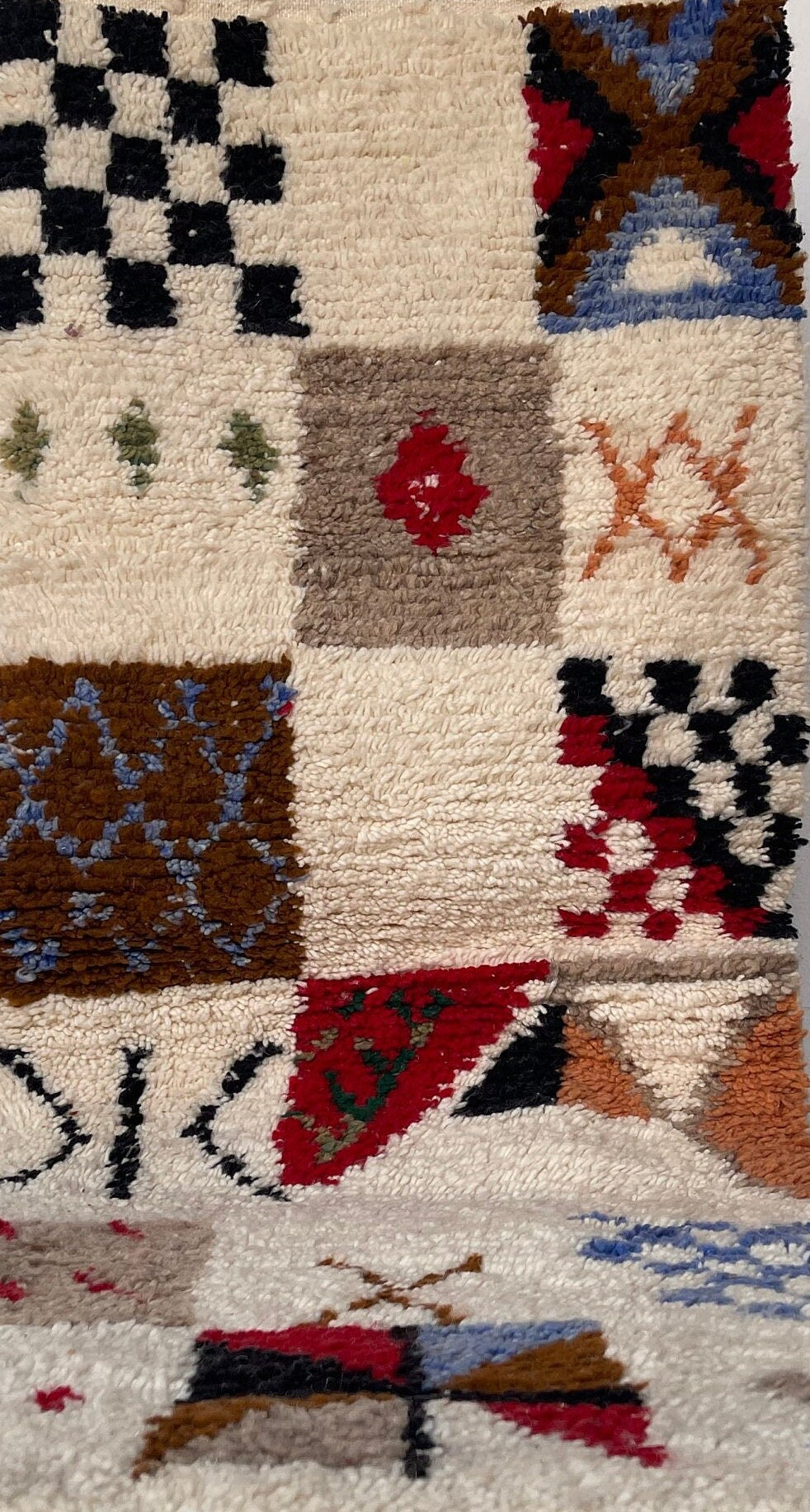 Gros plan sur un détail du tapis d'escalier berbère Hazmoud, poil long et motif multicolore vus de près