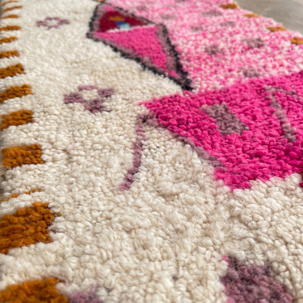 Close-up of a motif on the Ameln Berber stair runner, mottled ecru and pink runner and its edges