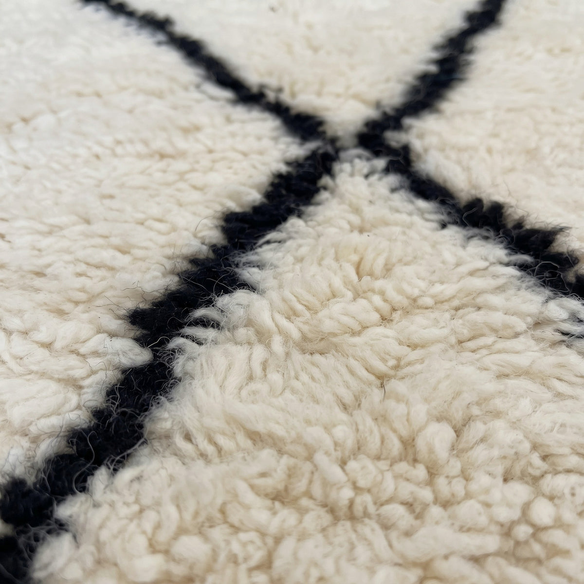 Close-up of a motif on the Kandar Berber stair runner, ecru ground, five stacked black diamonds