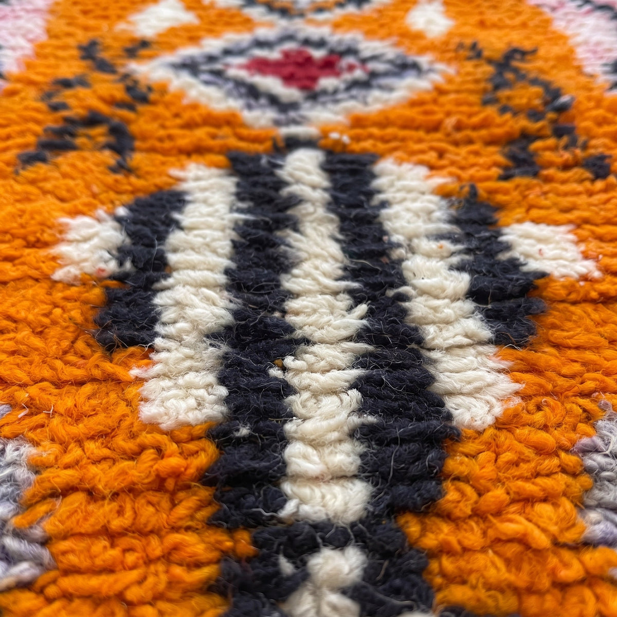 Close-up of a motif on the Khamlia Berber stair runner, bright orange ground with pink borders
