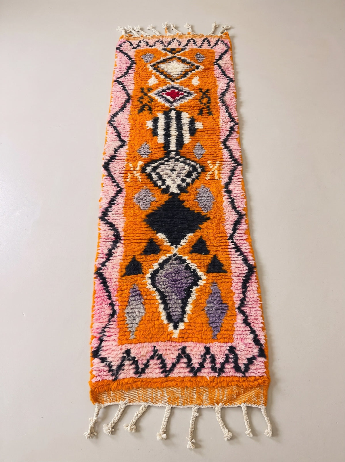 Khamlia Berber stair runner, Boujad style, in orange and pink, laid flat, bright orange ground, pink borders with a black zigzag